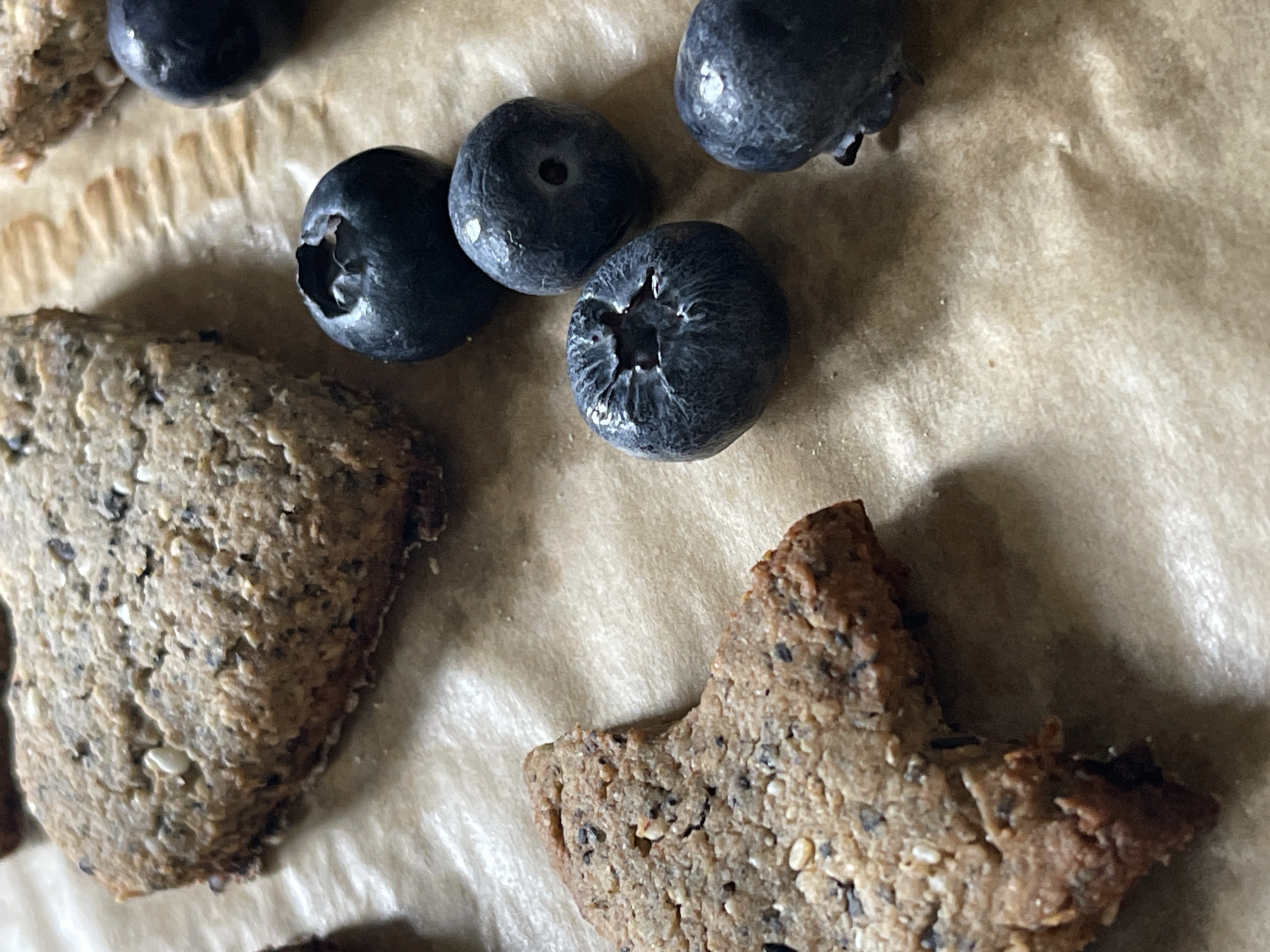 Fresh baked cookies and blueberries arranged on parchment paper
