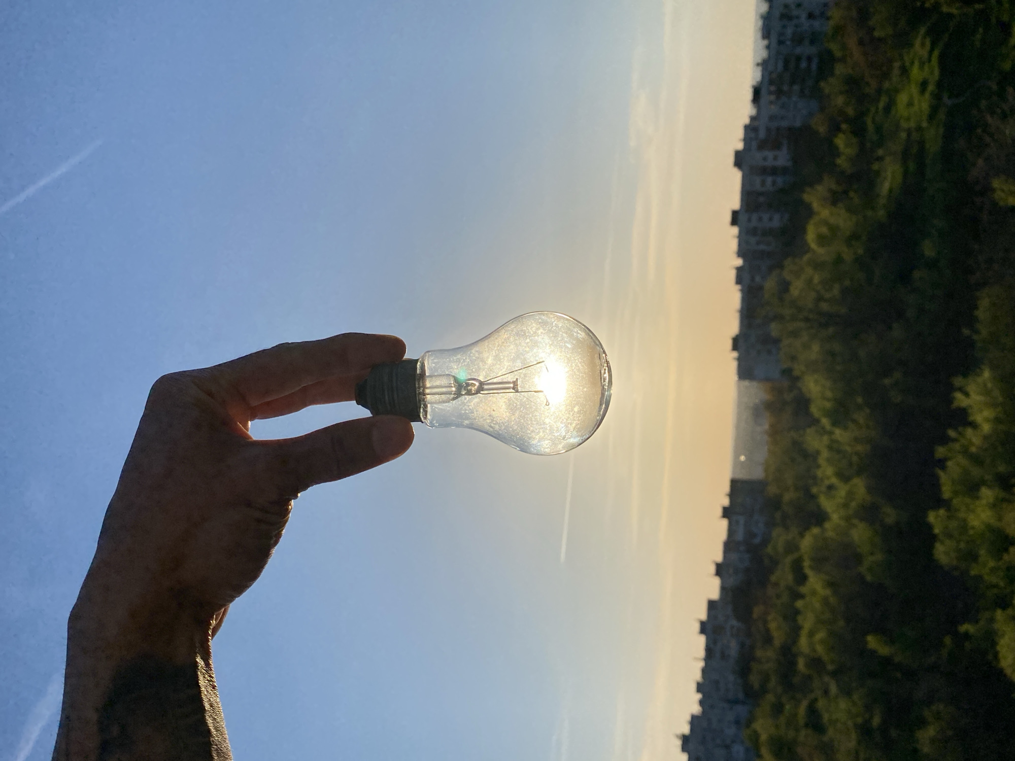 Hand holds lightbulb capturing sunlight in Pleven, Bulgaria