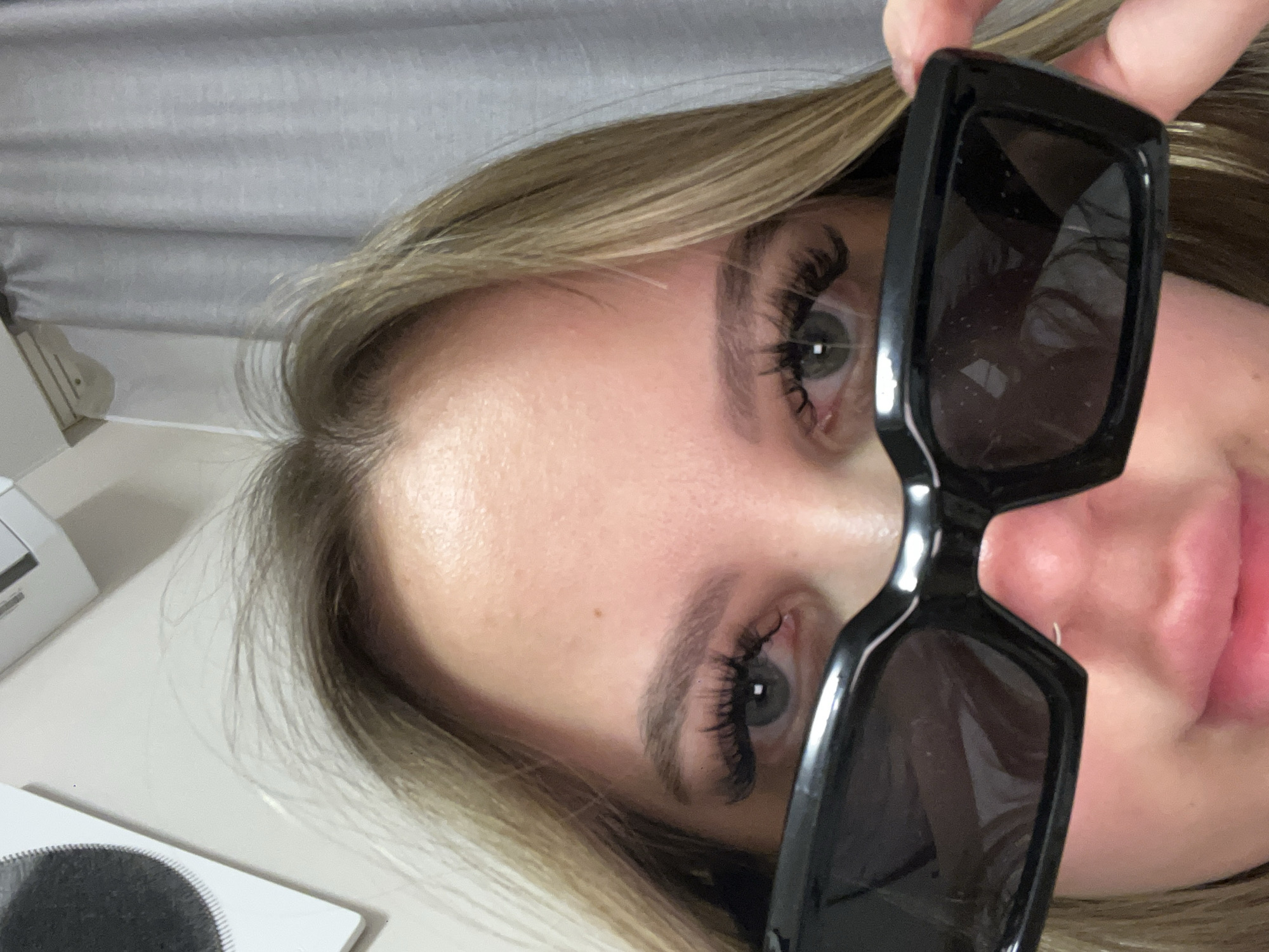Woman photographed with sunglasses, smartphone in Krasnodar evening