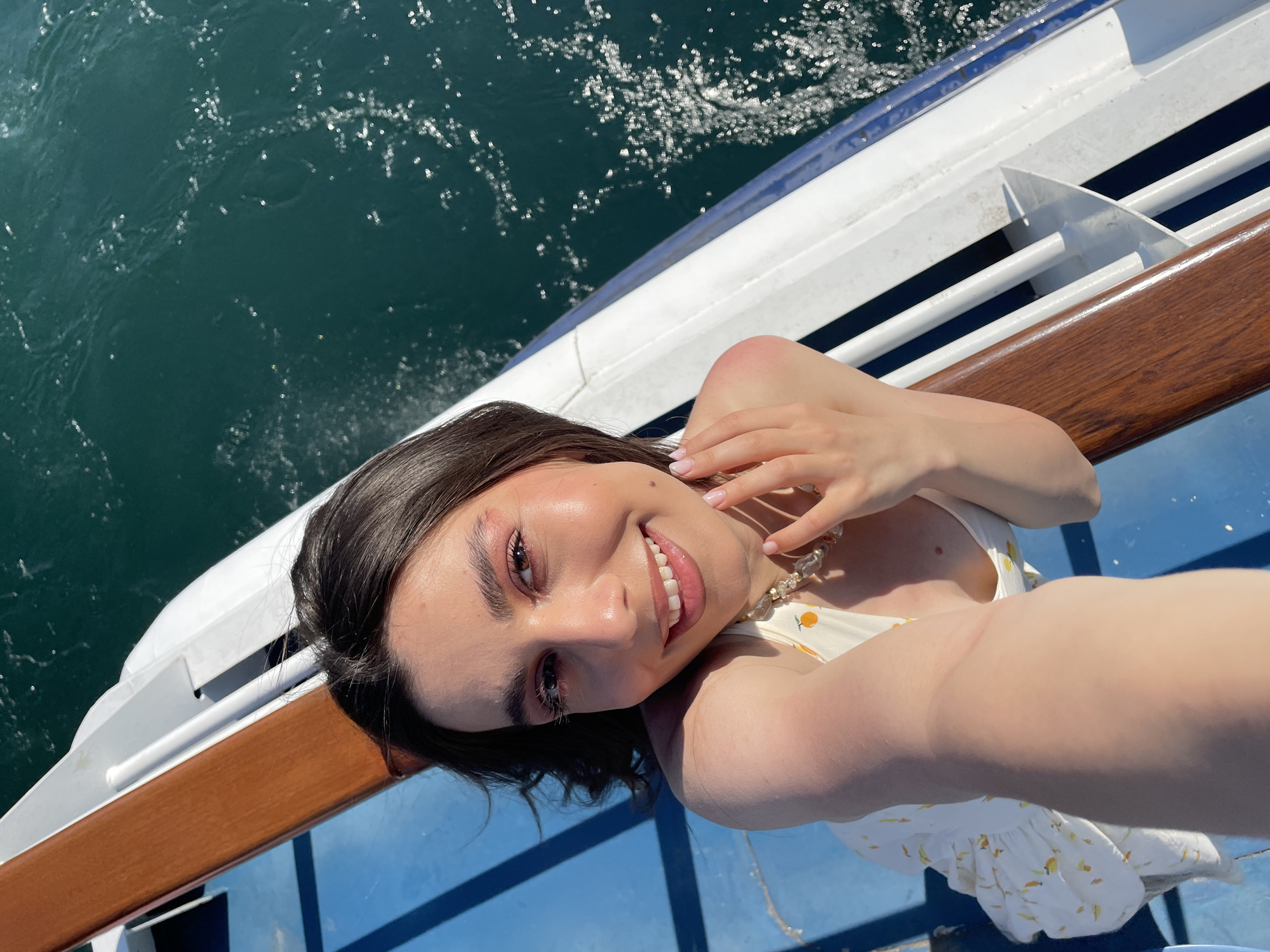 Women take selfies on boat near Colonno, Italy
