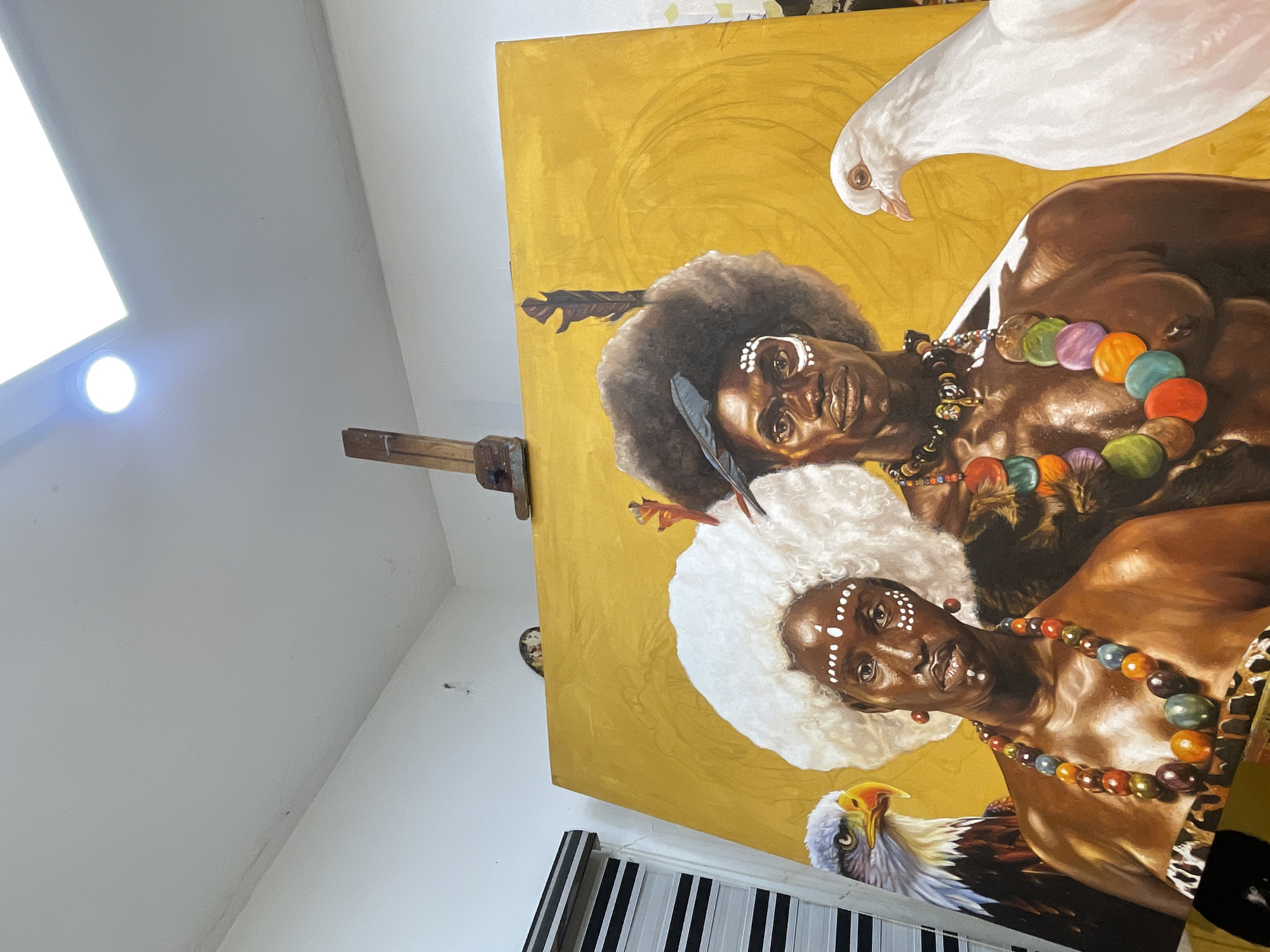 Artist works on traditional portrait painting in Ado studio