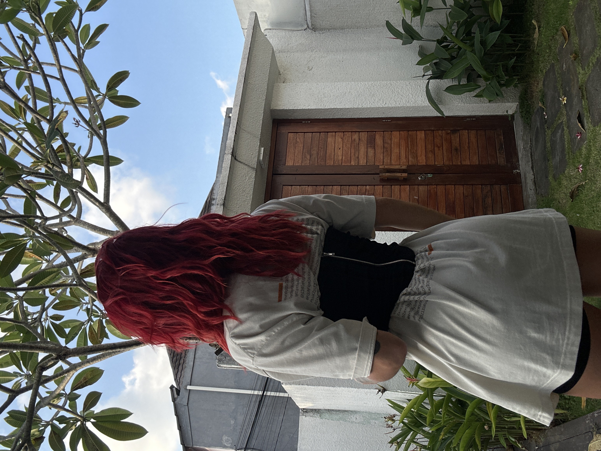 Red-haired person captured outdoors in North Kuta garden setting