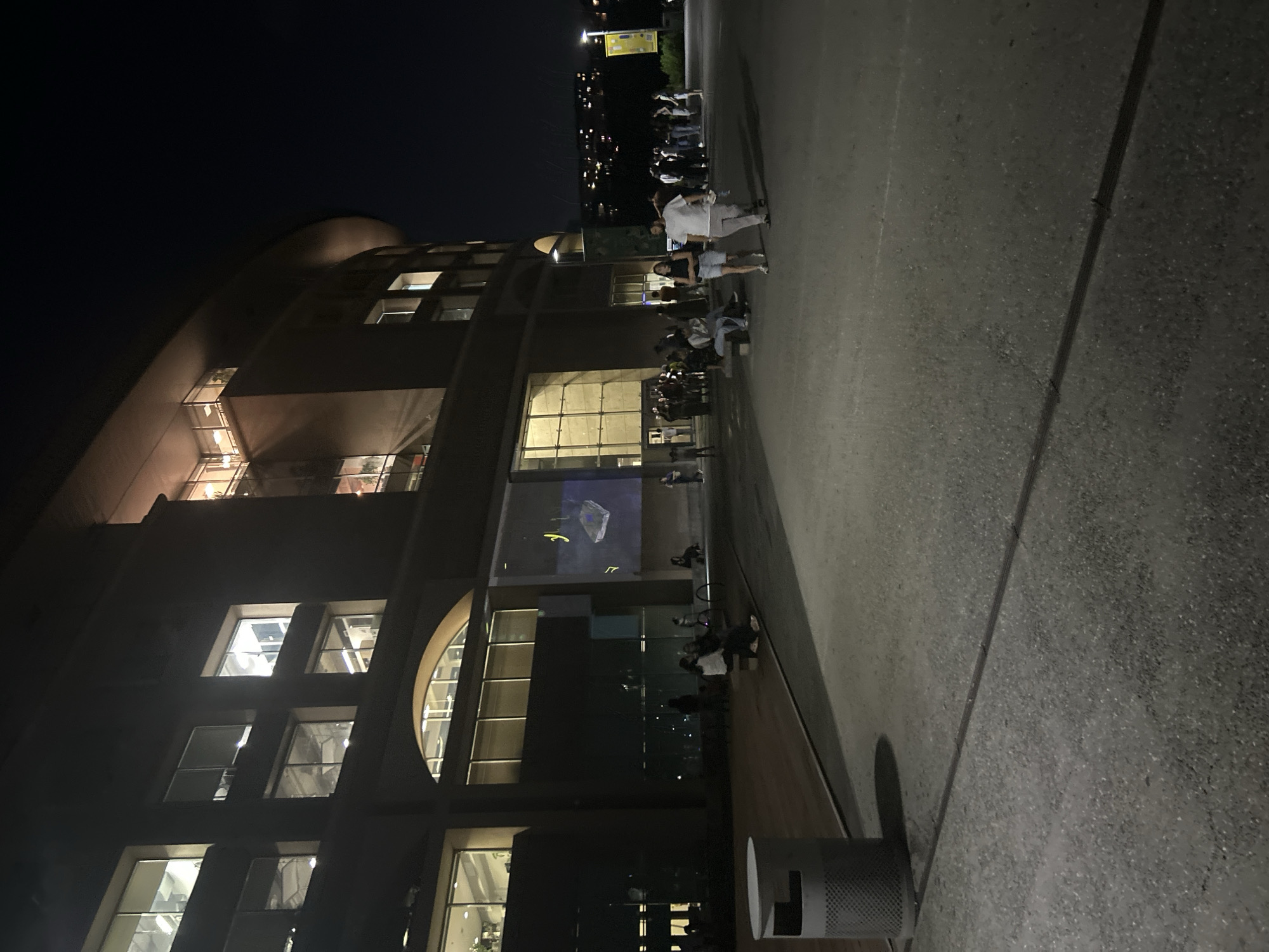 Evening gathering outside a large illuminated building in Yerevan