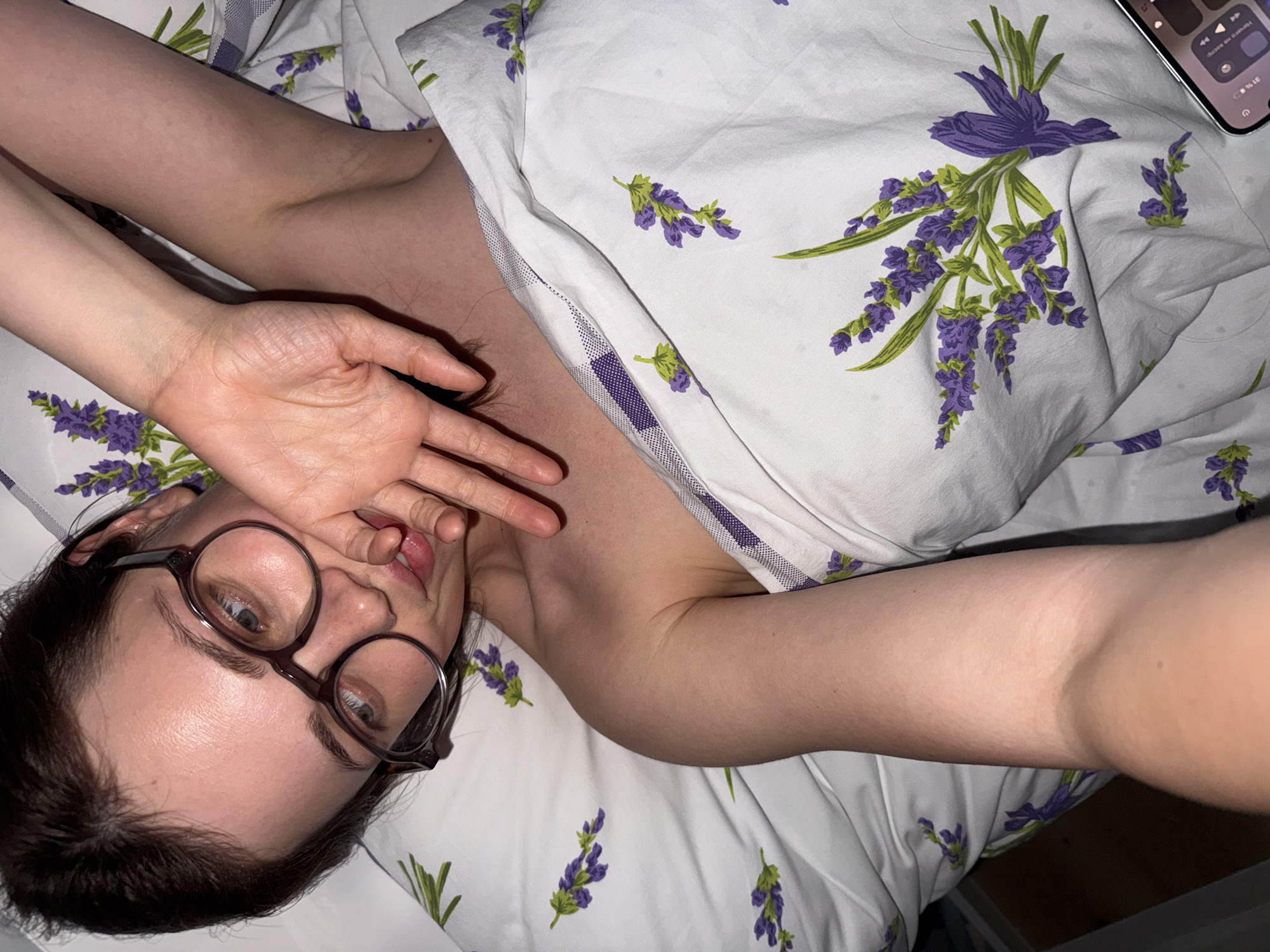 Person rests in lavender-patterned bedding in Hungarian village