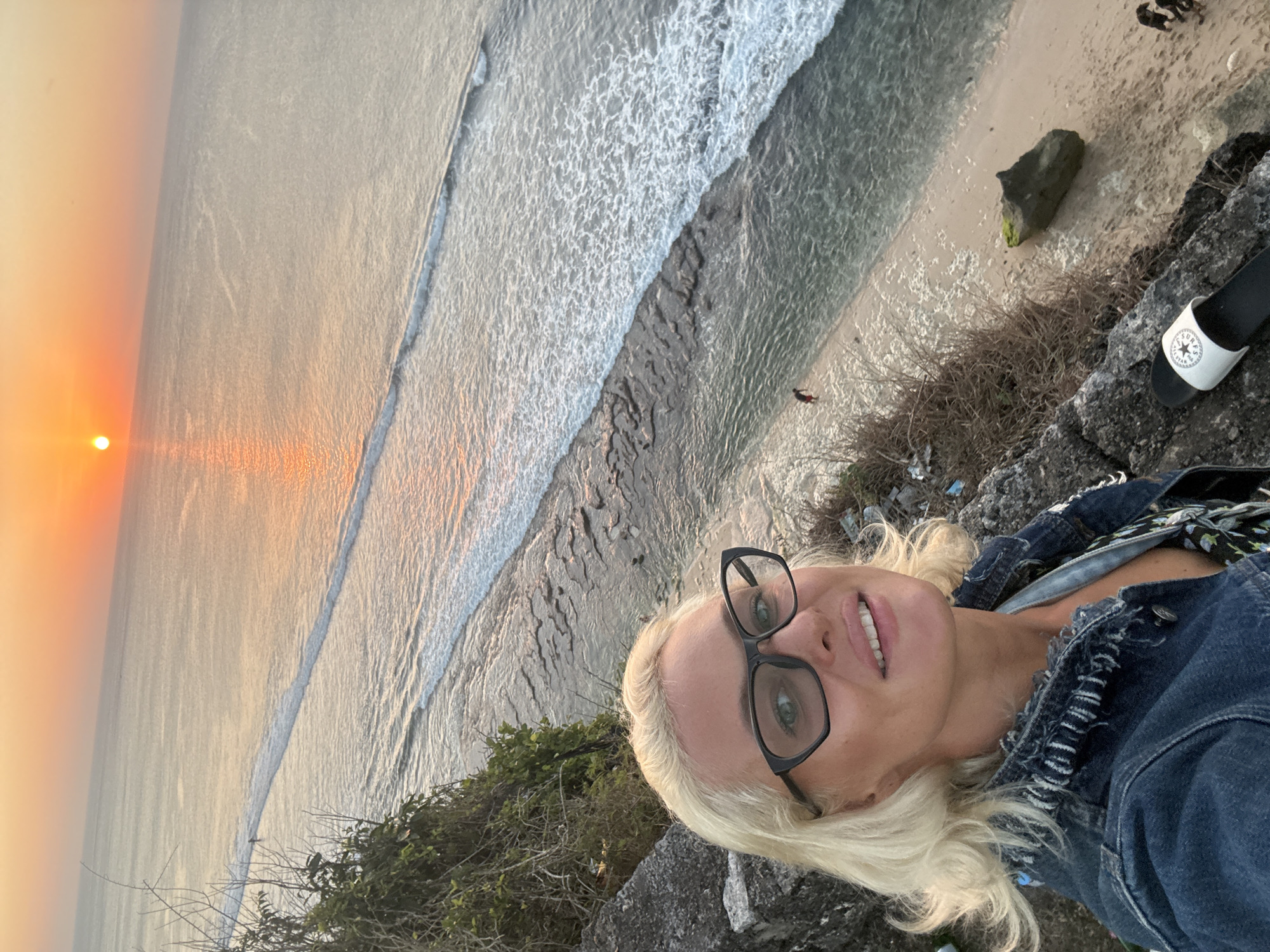 Cliffside ocean sunset, golden light across the water
