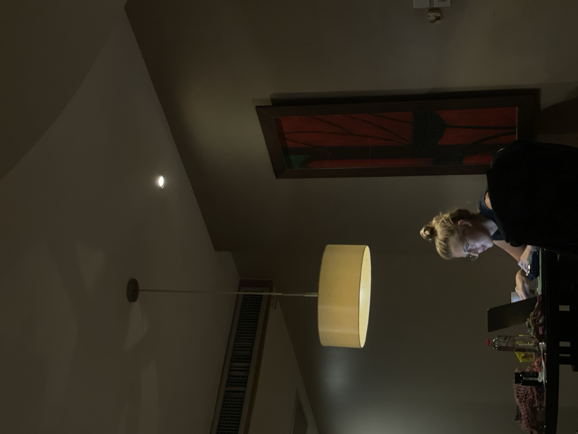 Blonde woman observed in dimly lit Bangkok room