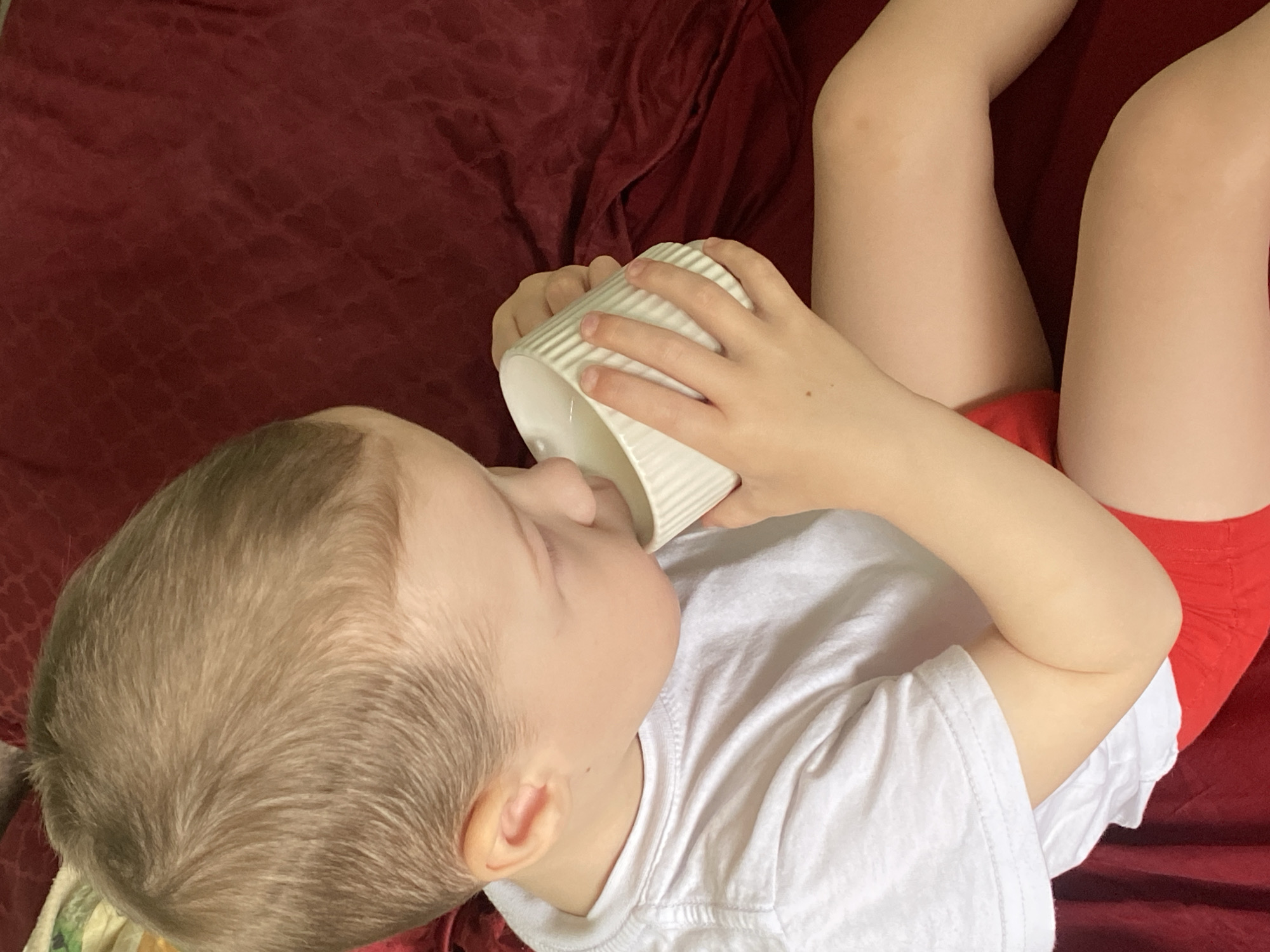 Child enjoys morning drink in bed, Sochi