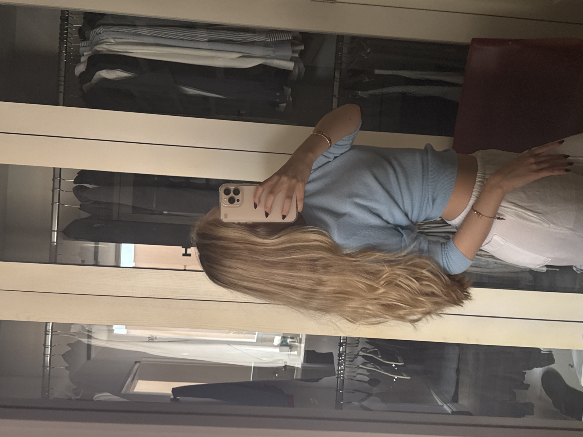 Woman takes selfie in front of clothing closet in Mexico City