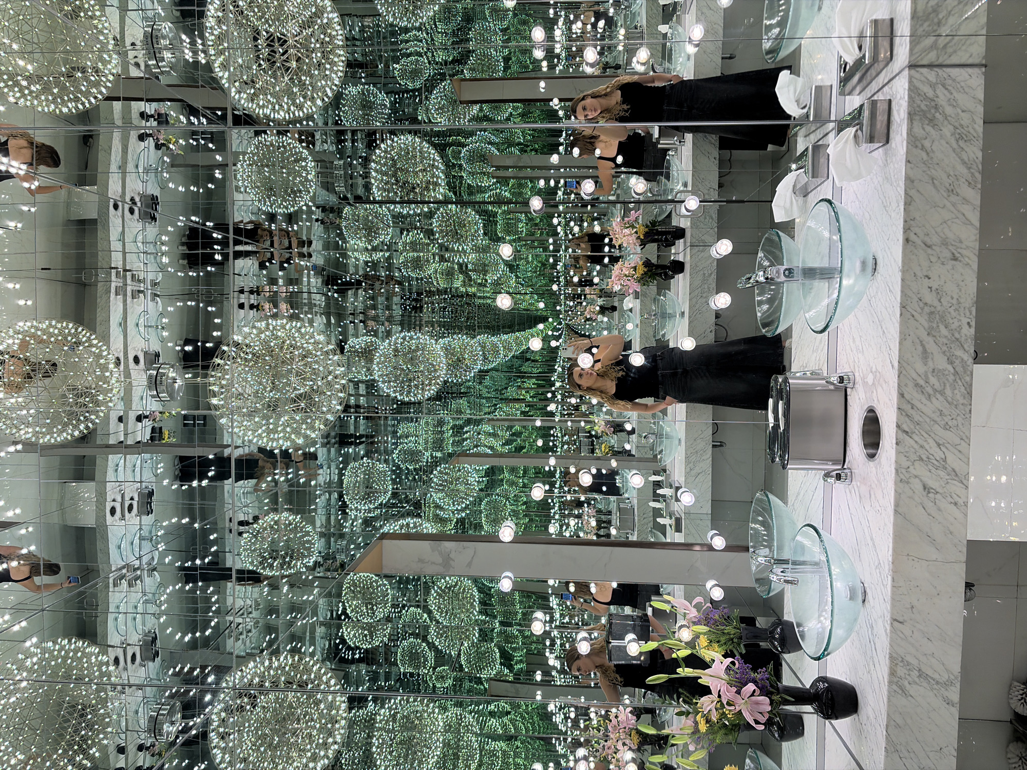Woman takes selfies in infinity mirror bathroom