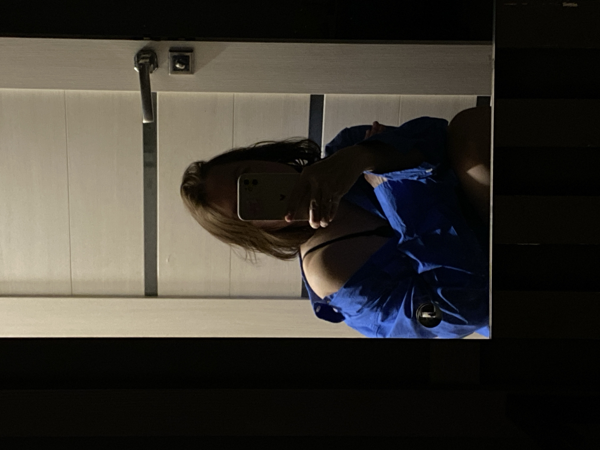 Woman takes mirror selfies in blue shirt, Chaikovsky Russia