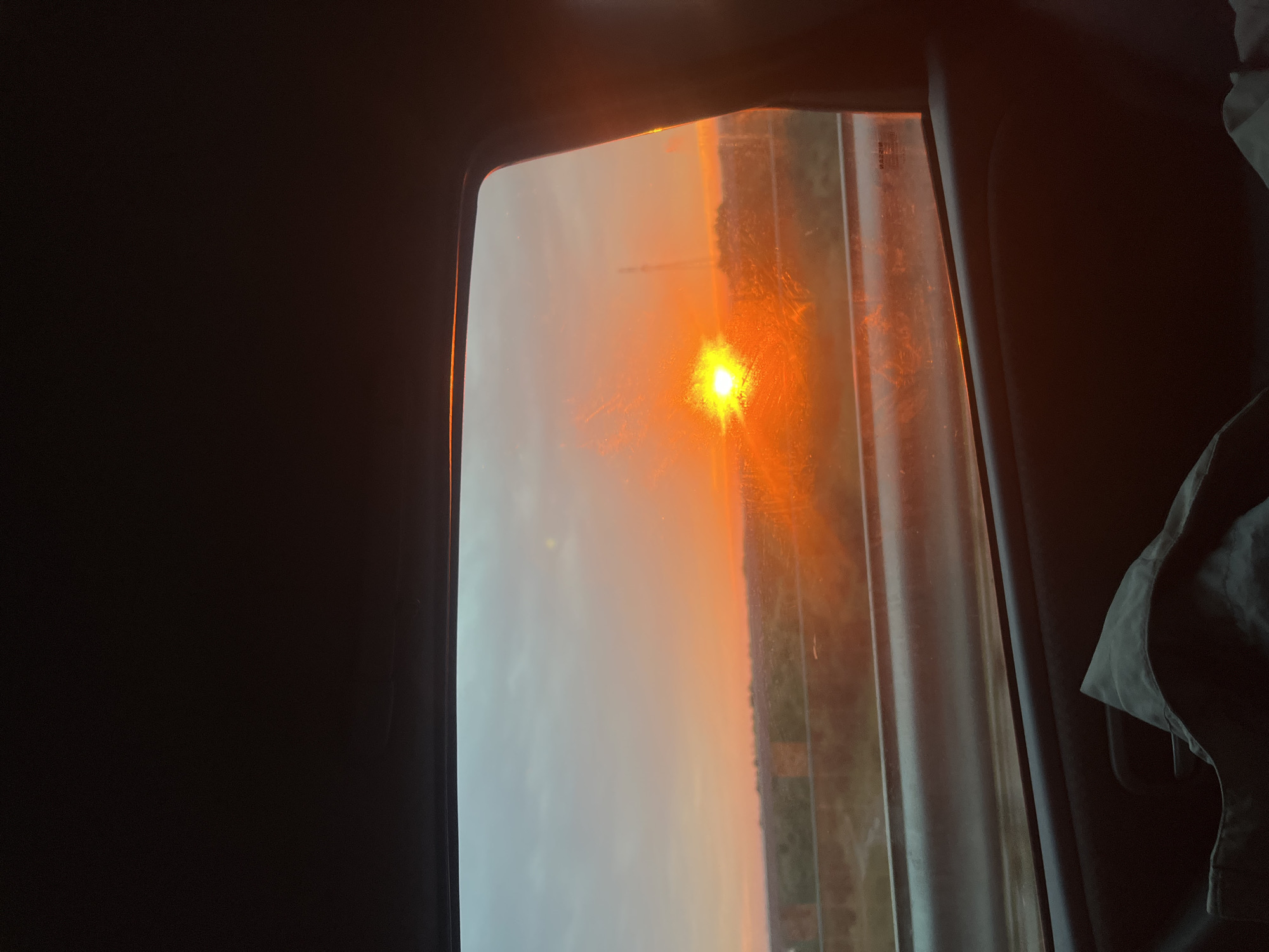 Orange sunset viewed through a car window in rural Belarus