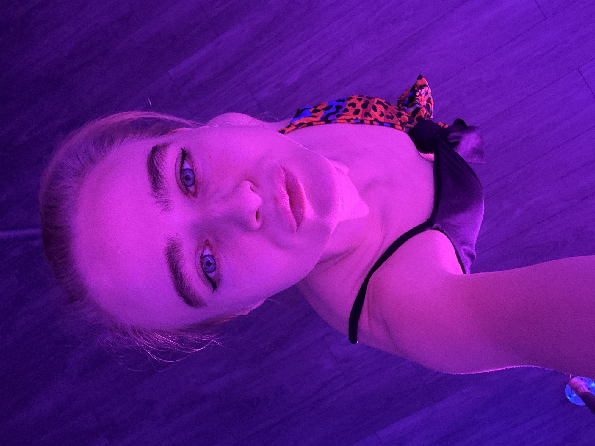 Pole dancing class observed at purple-lit studio