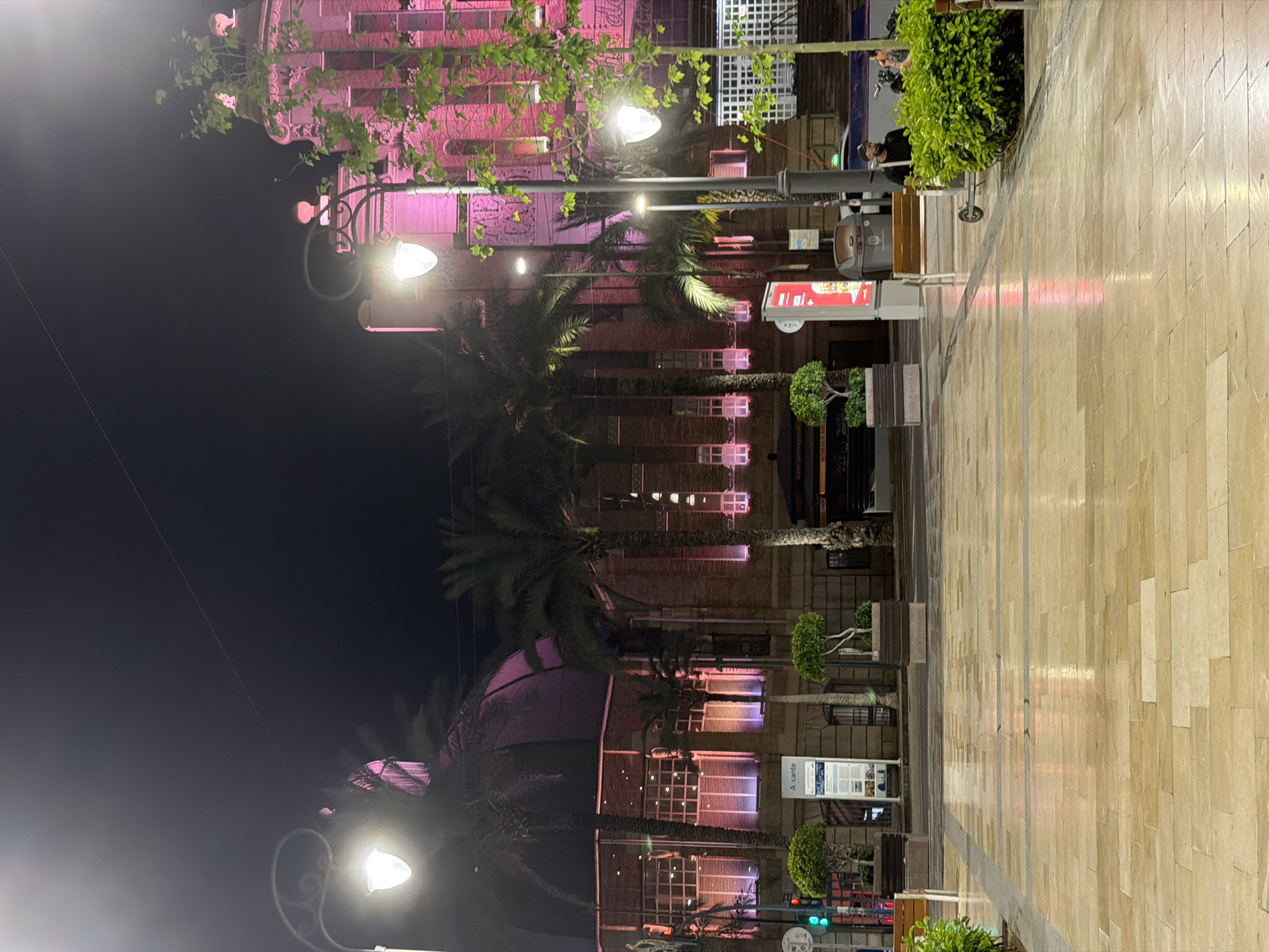 Two women walk stone streets of Alicante at night