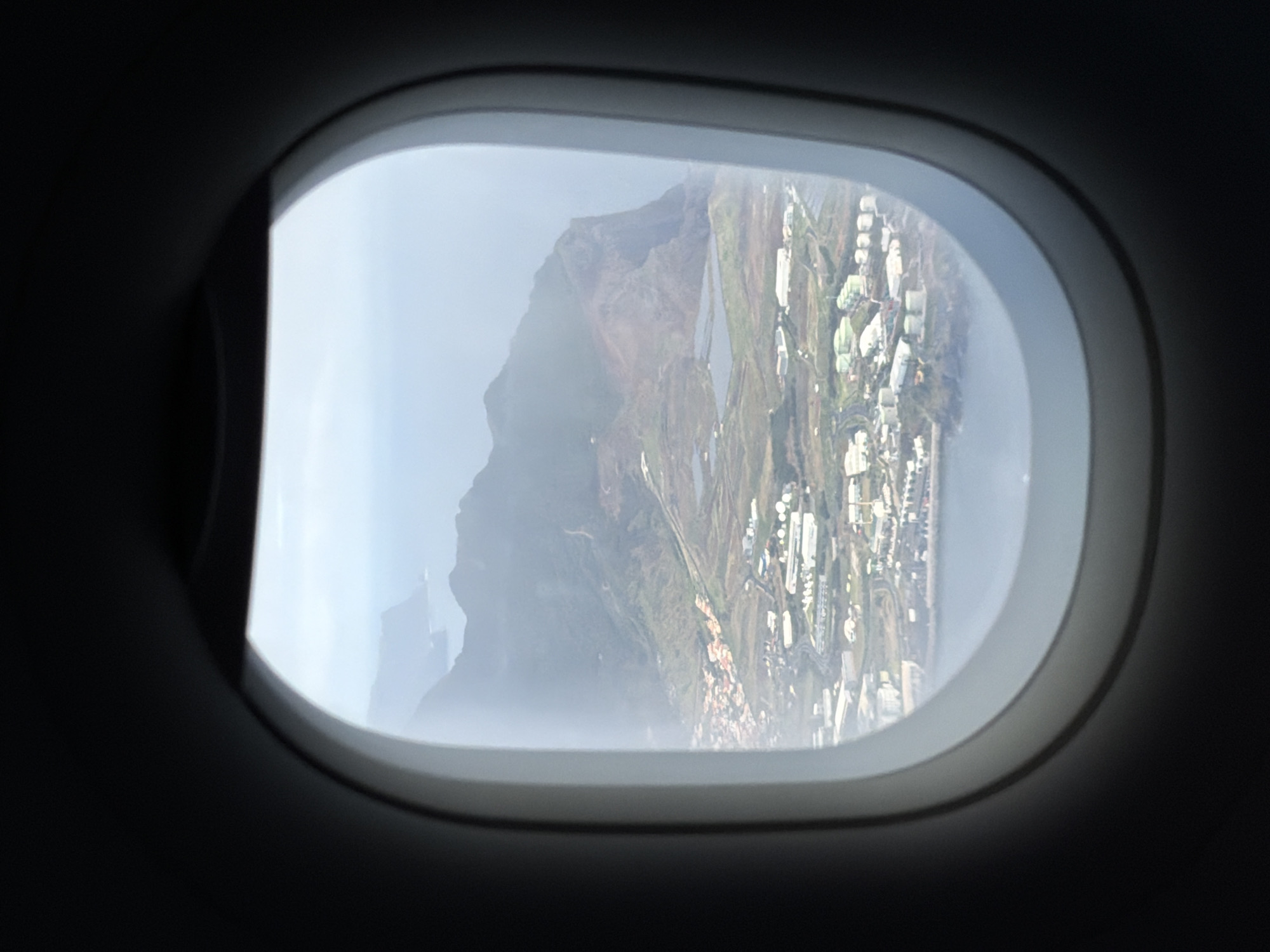 Airplane passenger captures foggy mountain view over Caniço, Portugal