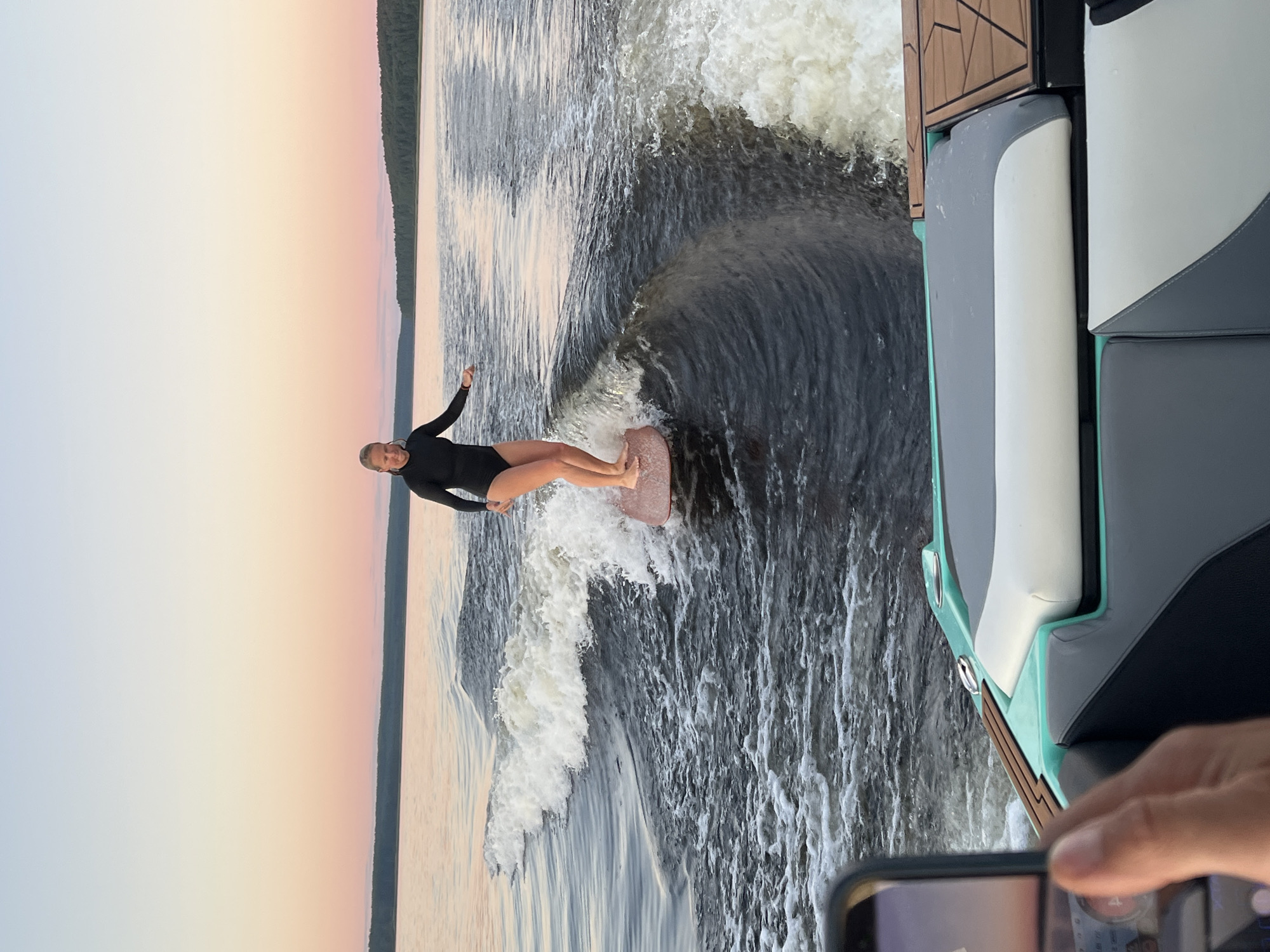 Wake surfing session on a Gromovo lake at sunset