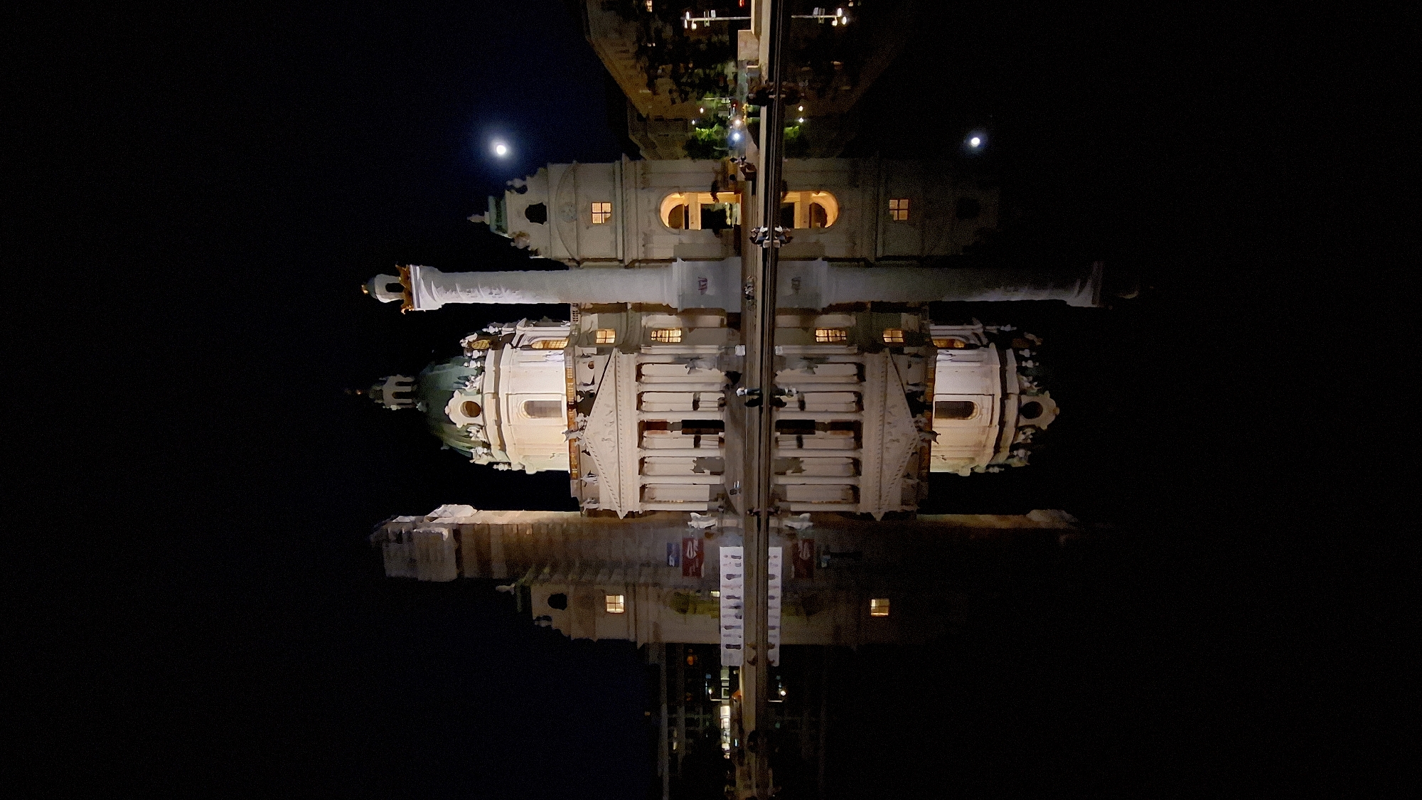 Vienna's Karlskirche reflects in water during evening illumination