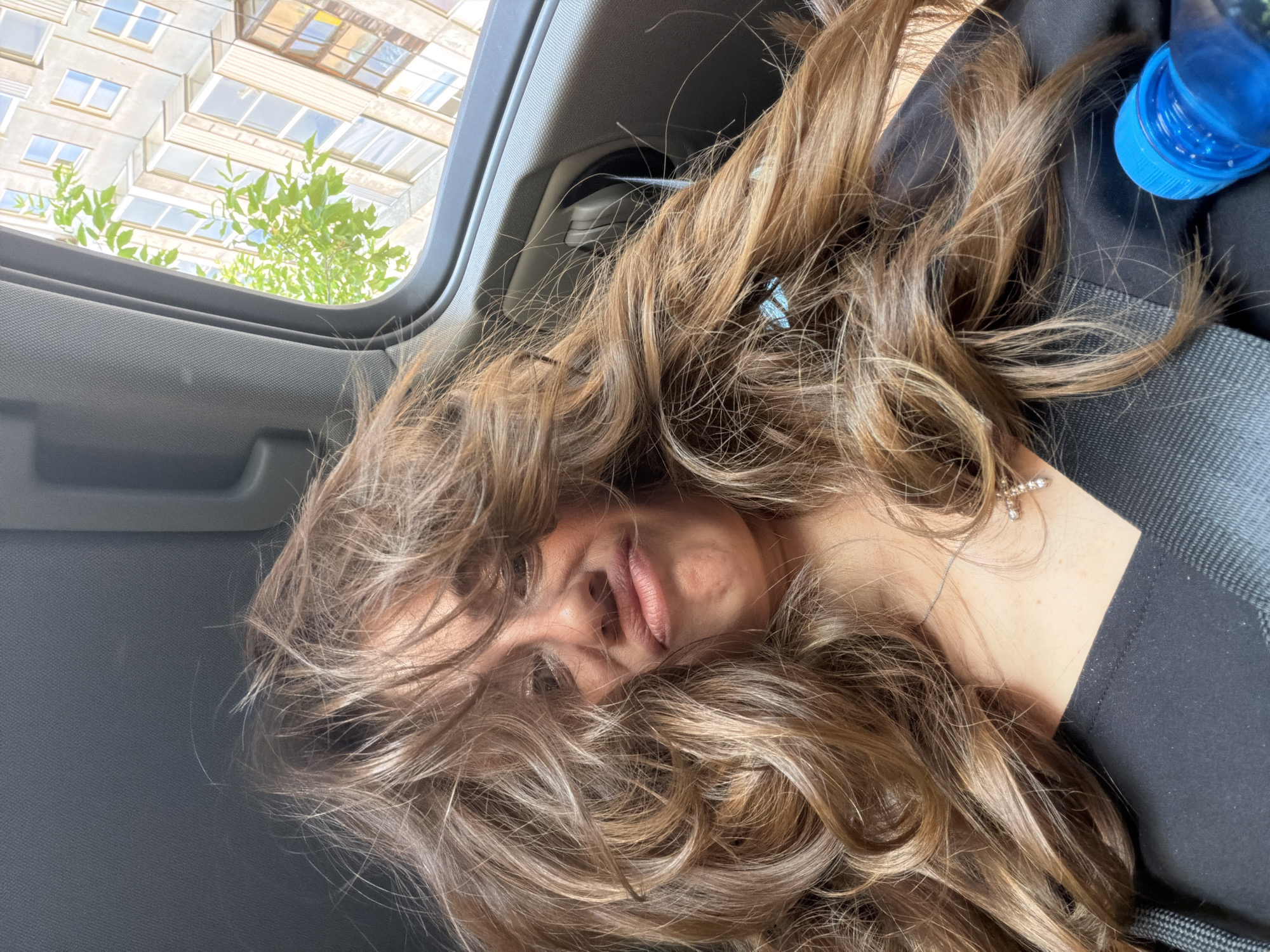 Low-angle interior car shot in Krasnoyarsk, hair spread across frame.