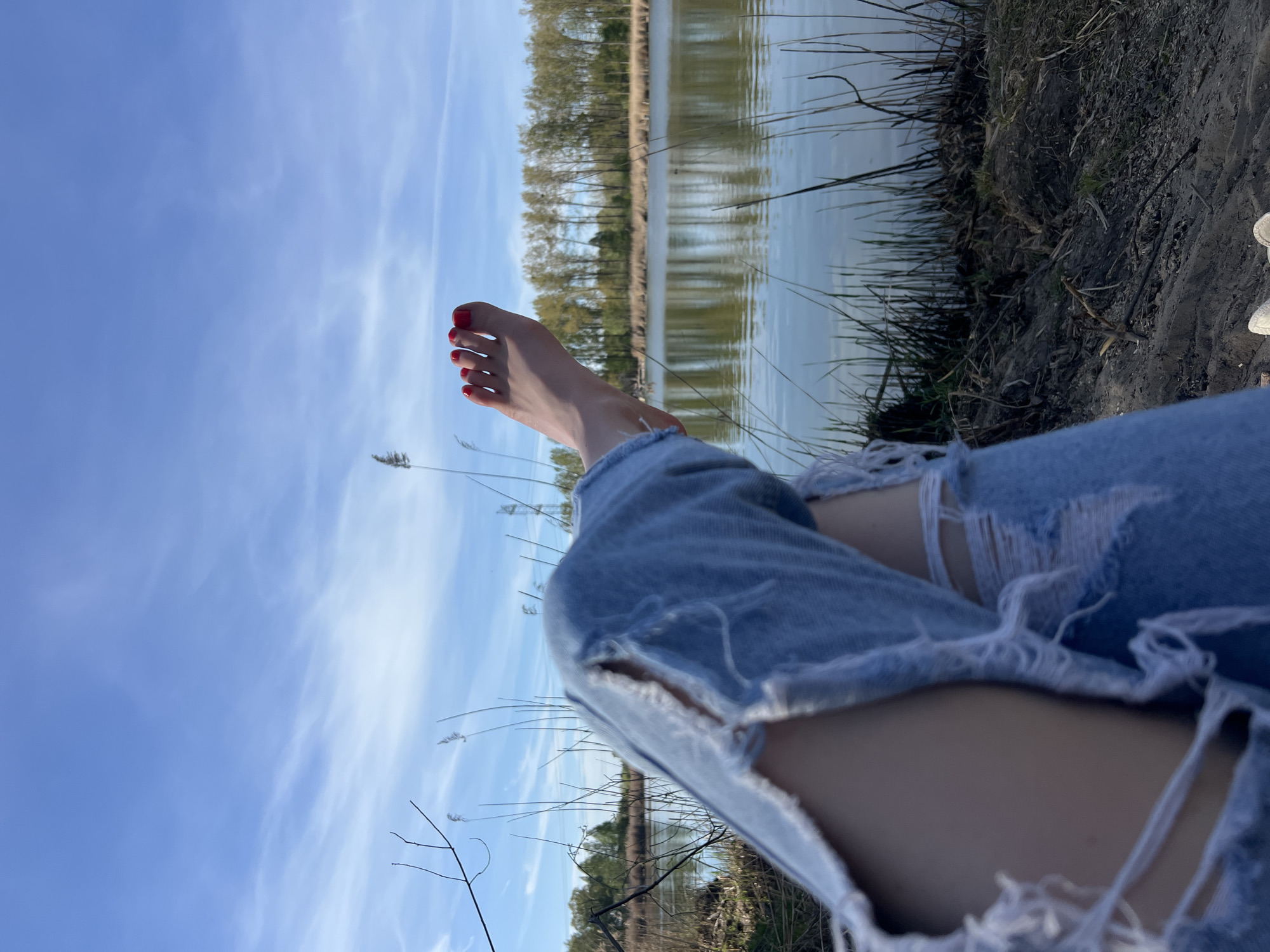 Person enjoys lakeside afternoon with beer in Ciemne, Poland