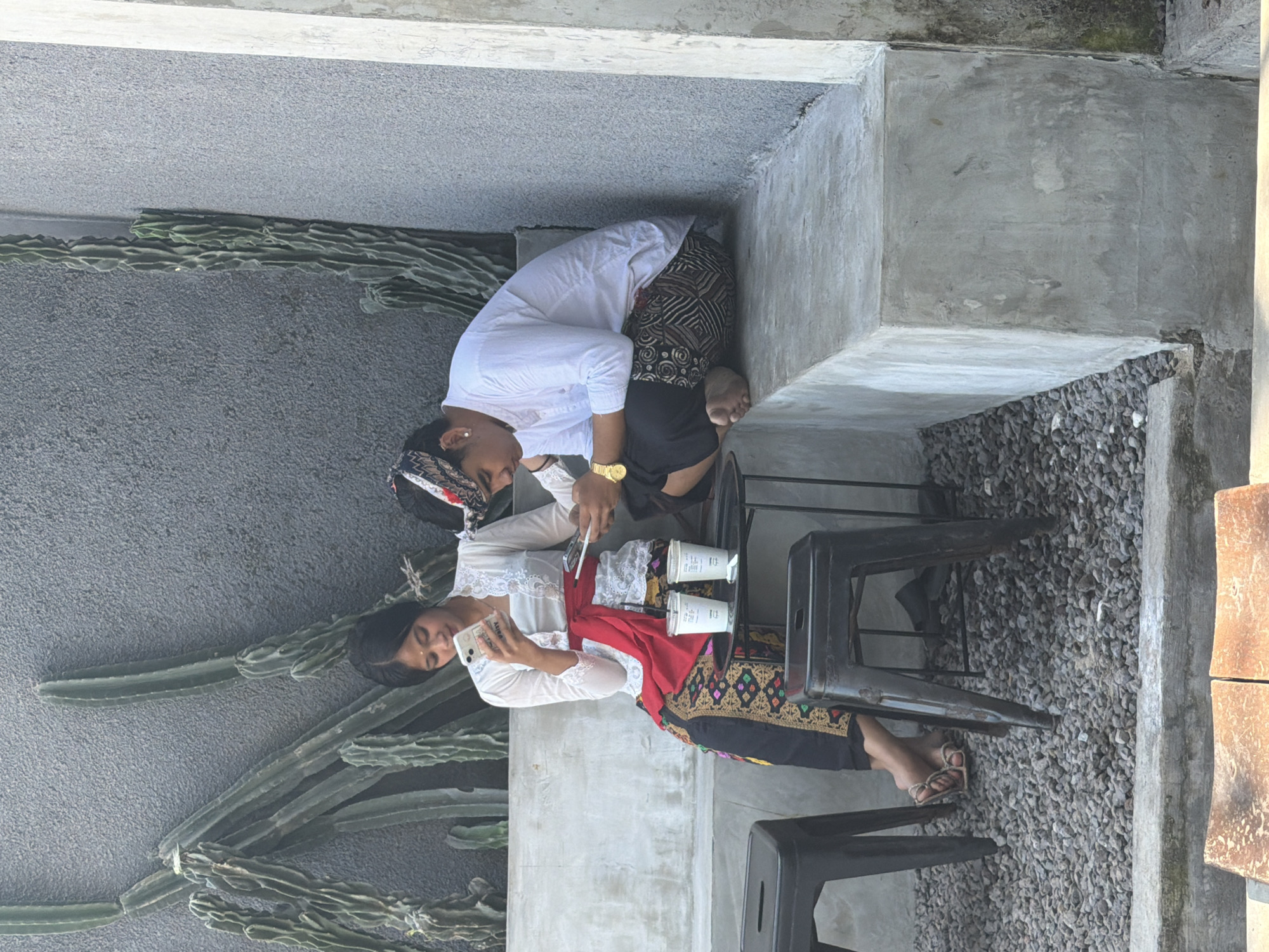 Woman uses phone at sunny Kuta beachside location