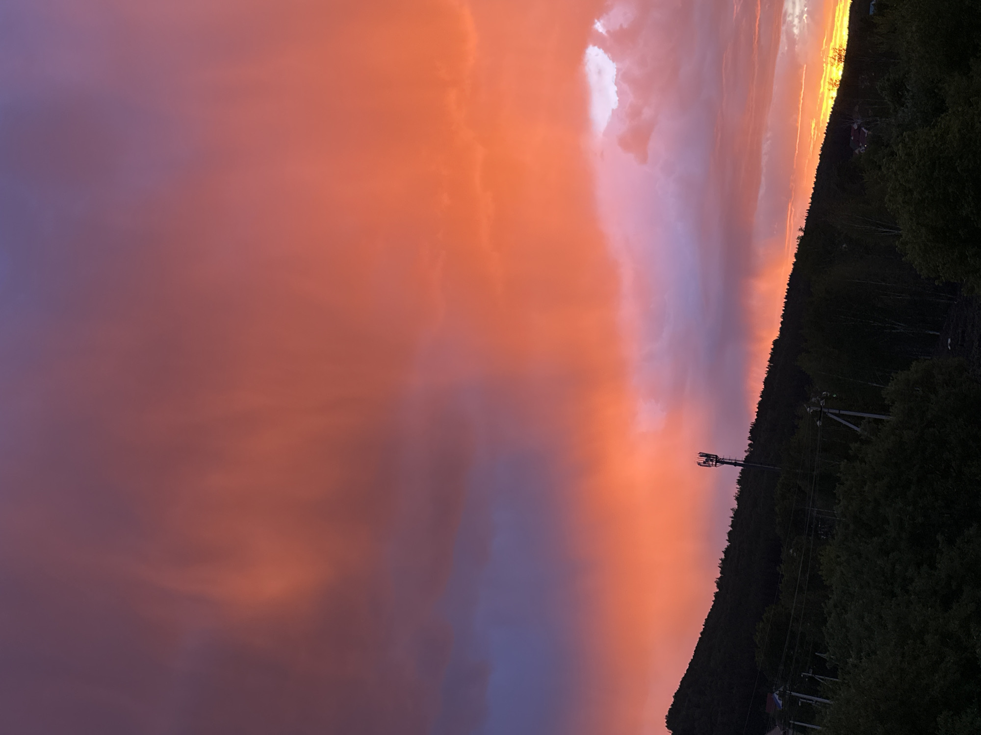 Dramatic sunset displays vibrant colors over rural landscape