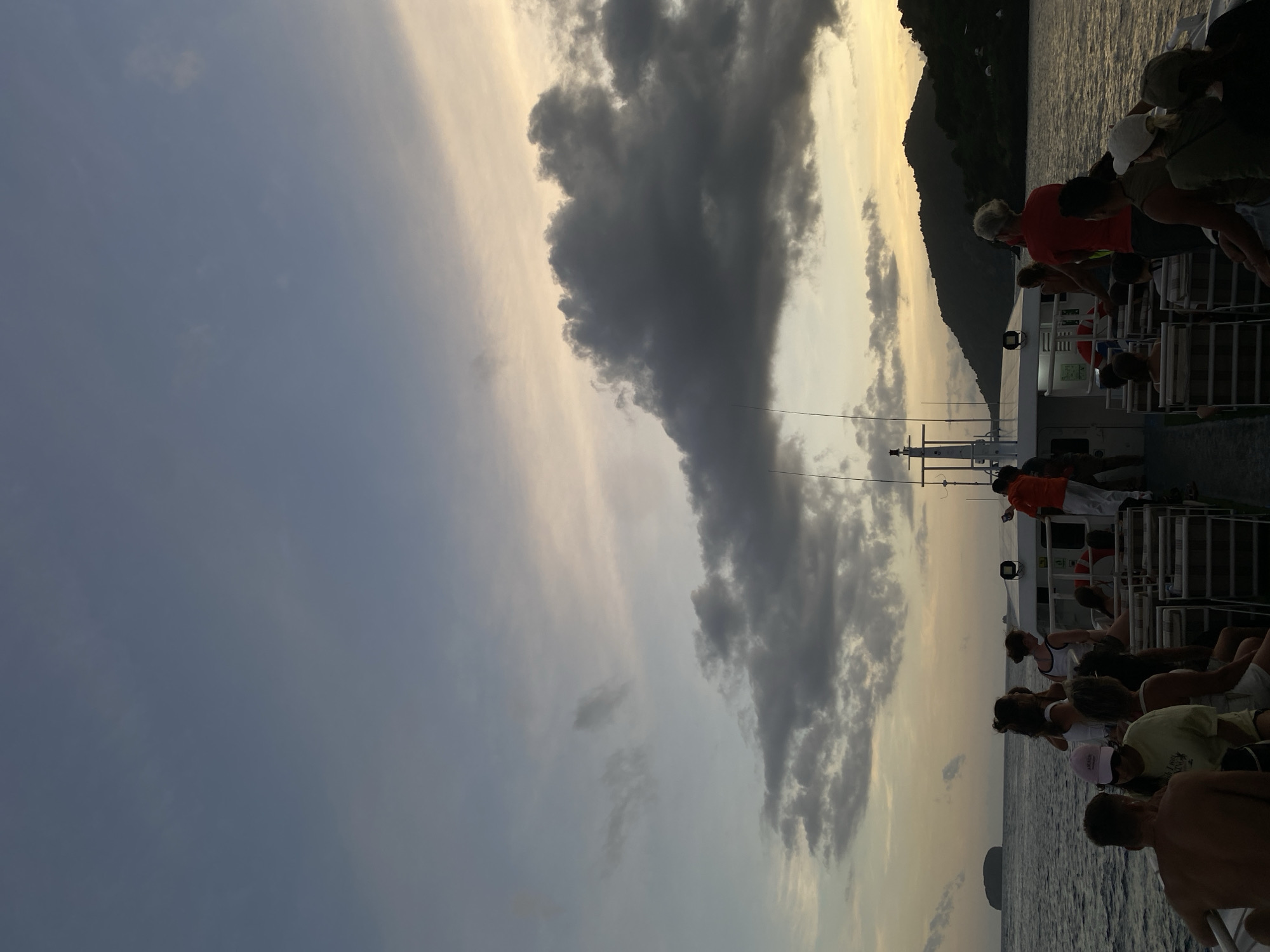 Boat passengers travel past rocky island near Karangasem Indonesia