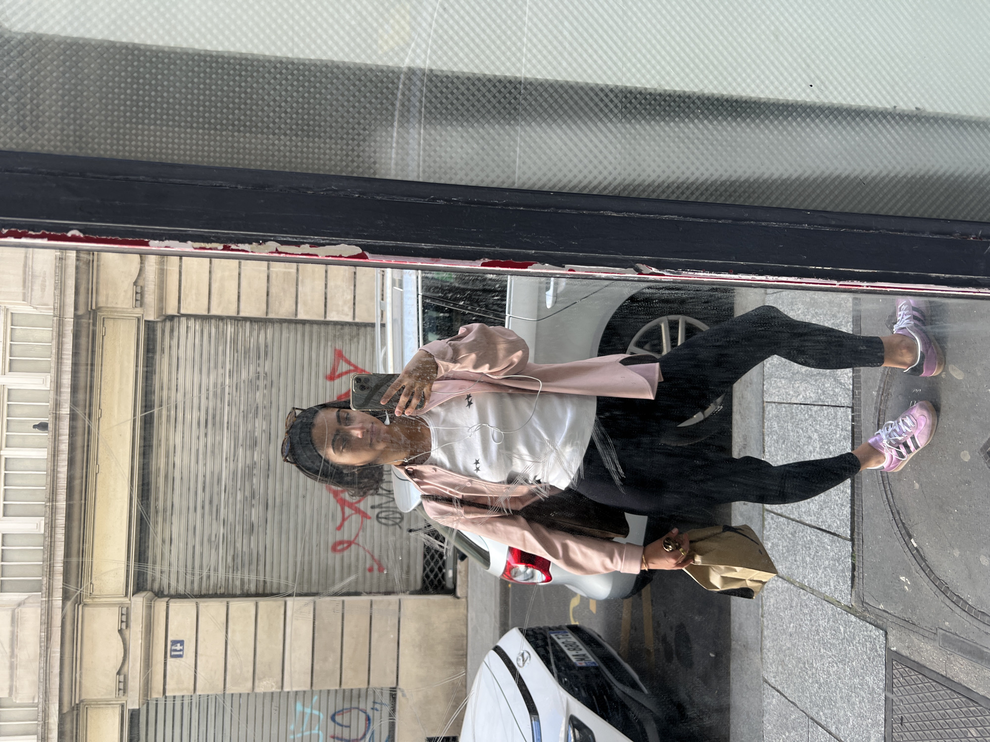Woman captures selfie in Paris shop window reflection