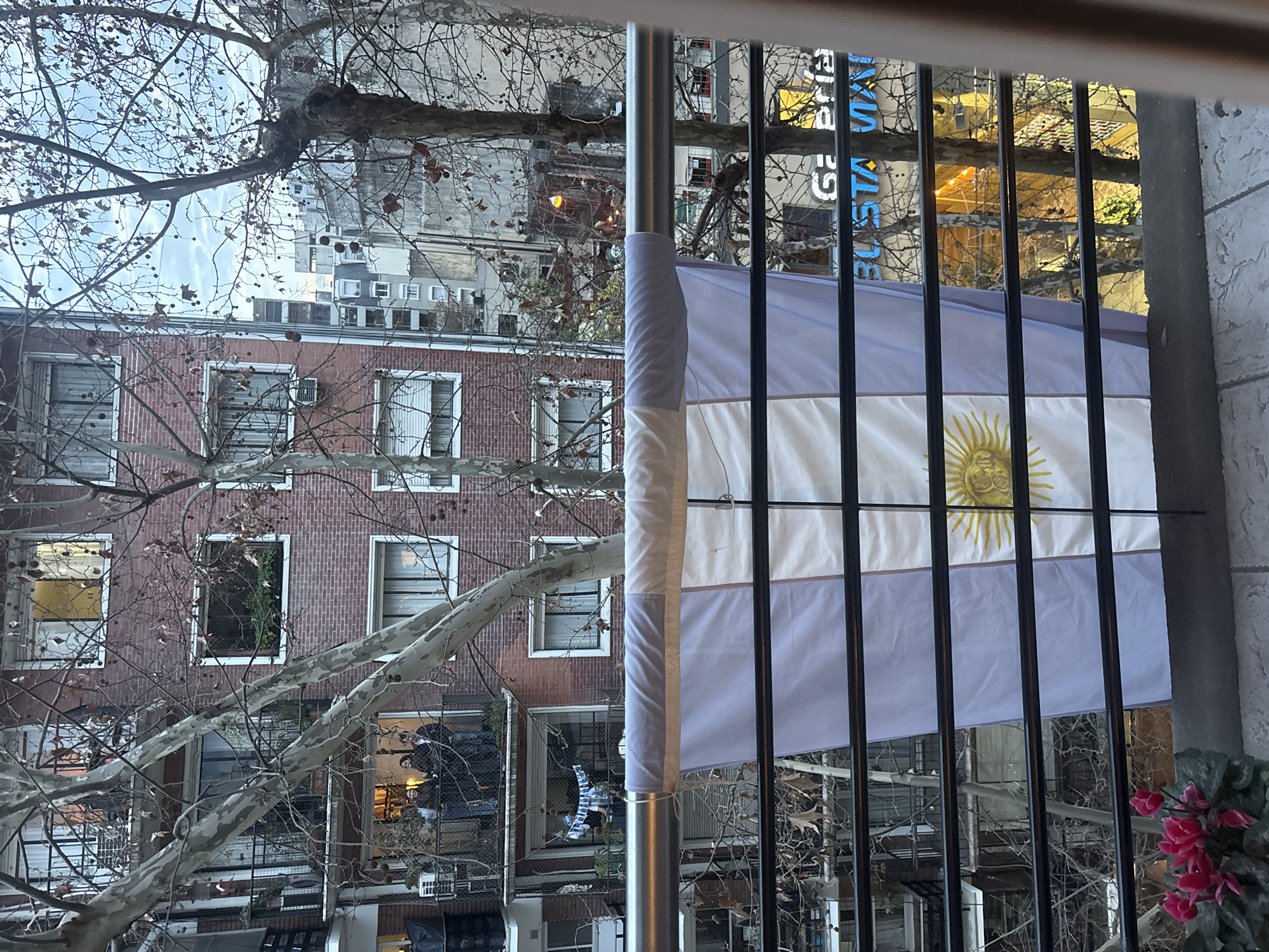 Watching football from a flag-draped Buenos Aires balcony