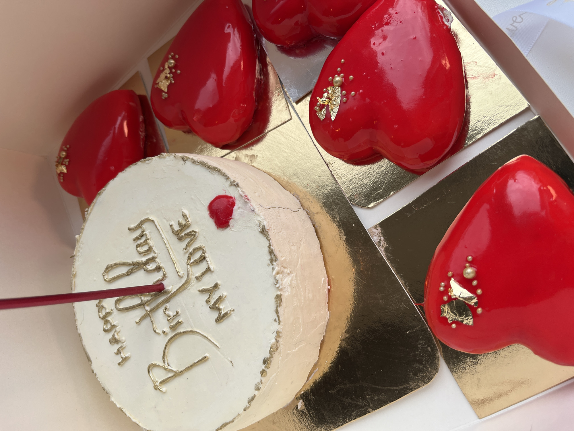 Ornate heart pastries and decorated cake observed in box