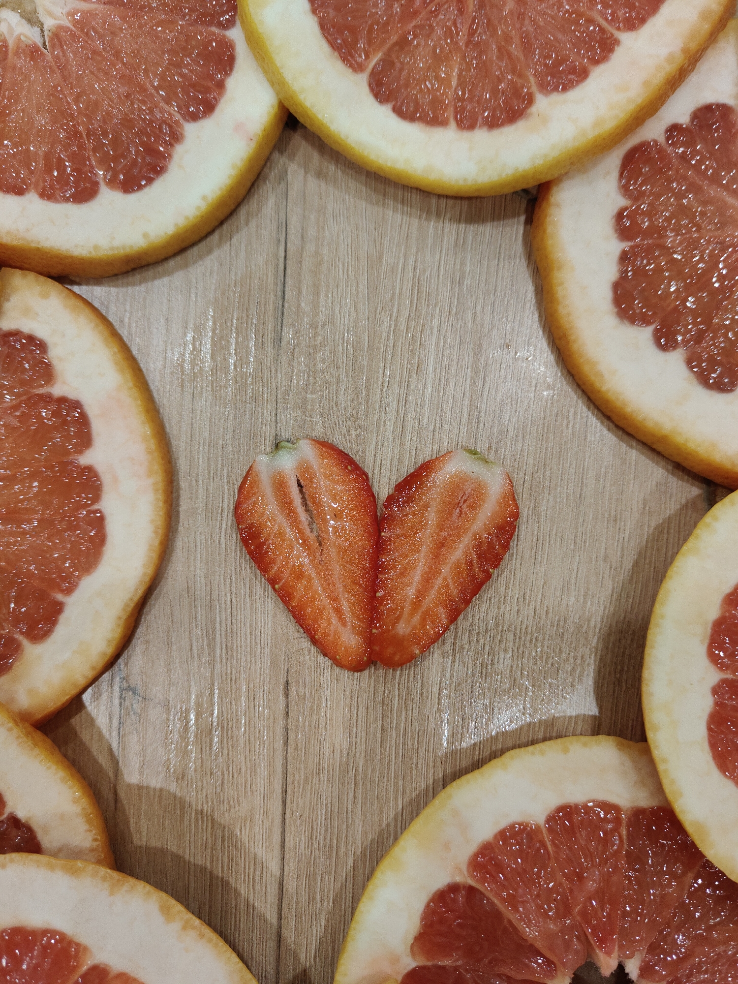 Woman Creates Heart-Shaped Fruit Art Display with Citrus and Strawberries