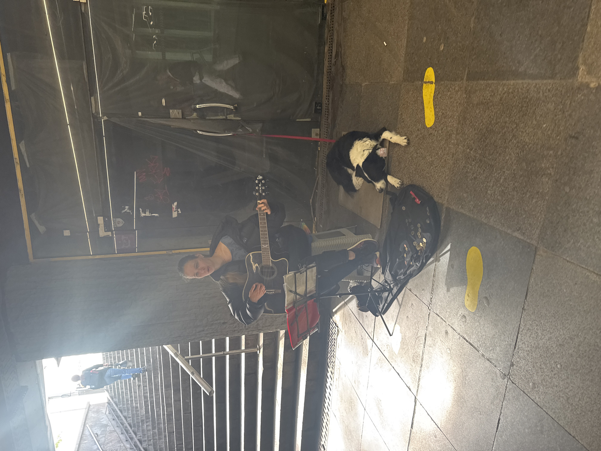 Street musician performs with guitar near Sofia underground passage