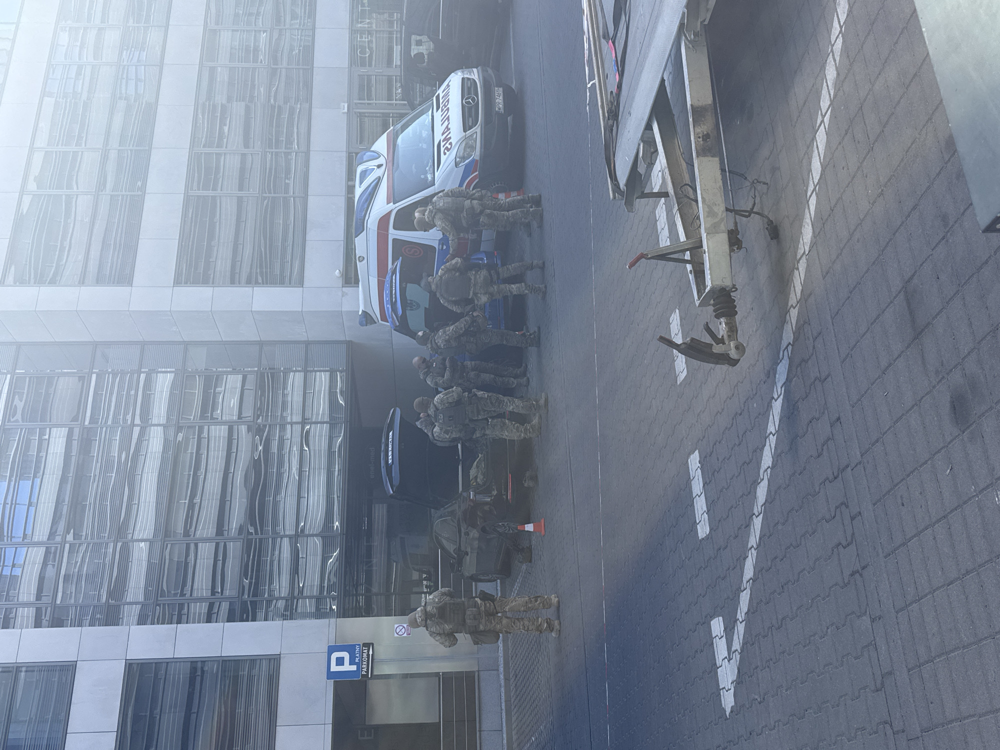Military personnel gather around ambulance on Warsaw street