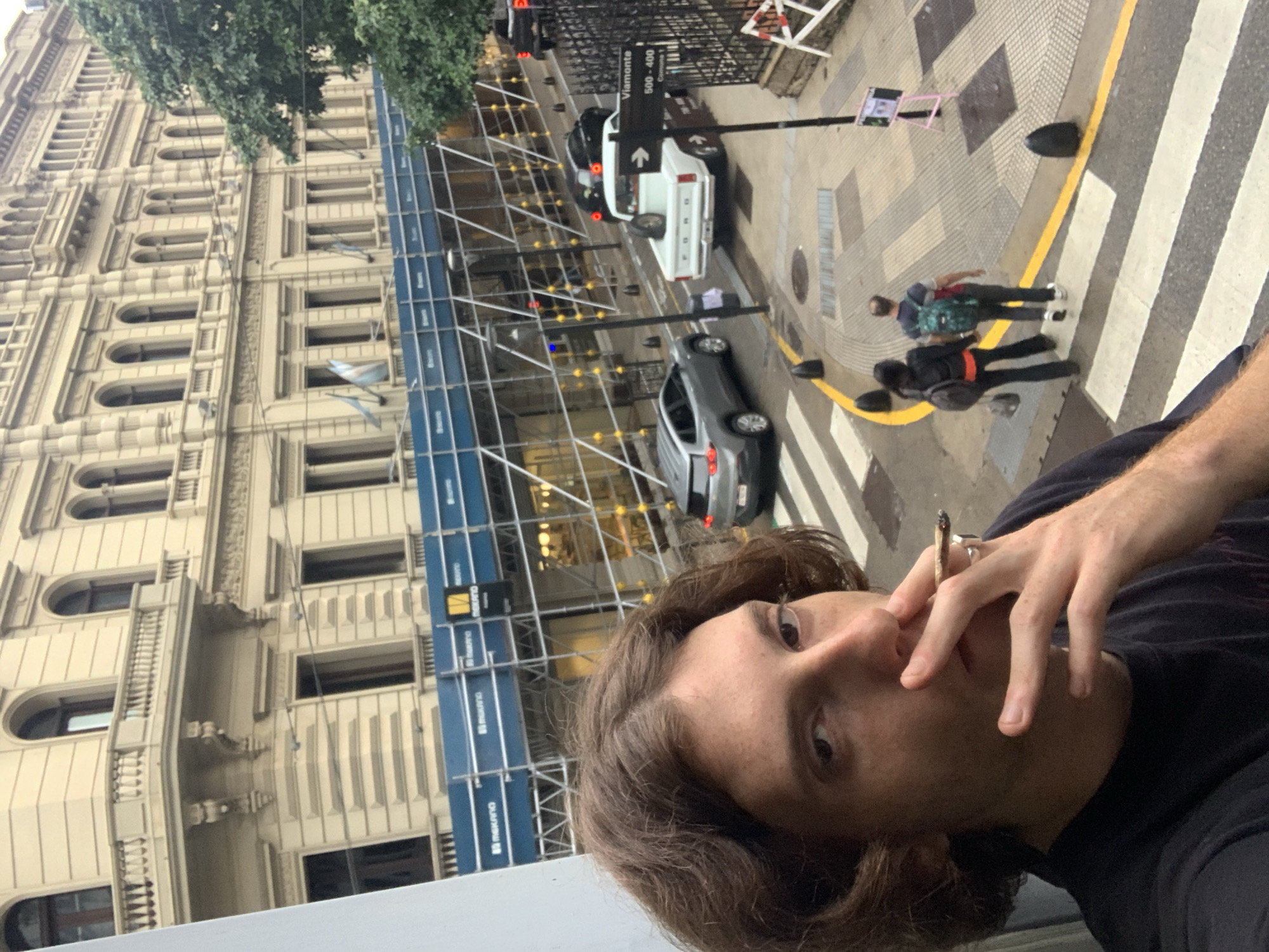 Person smoking hand-rolled cigarette observed on Buenos Aires street