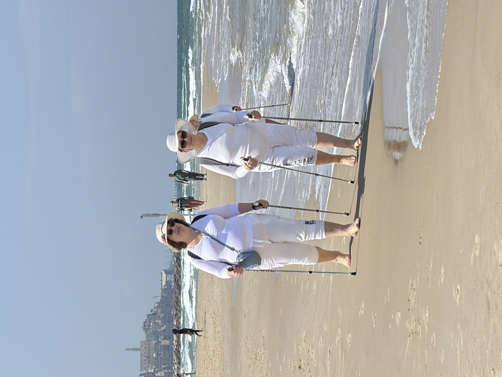 Elderly women Nordic walking on Tel Aviv beach morning