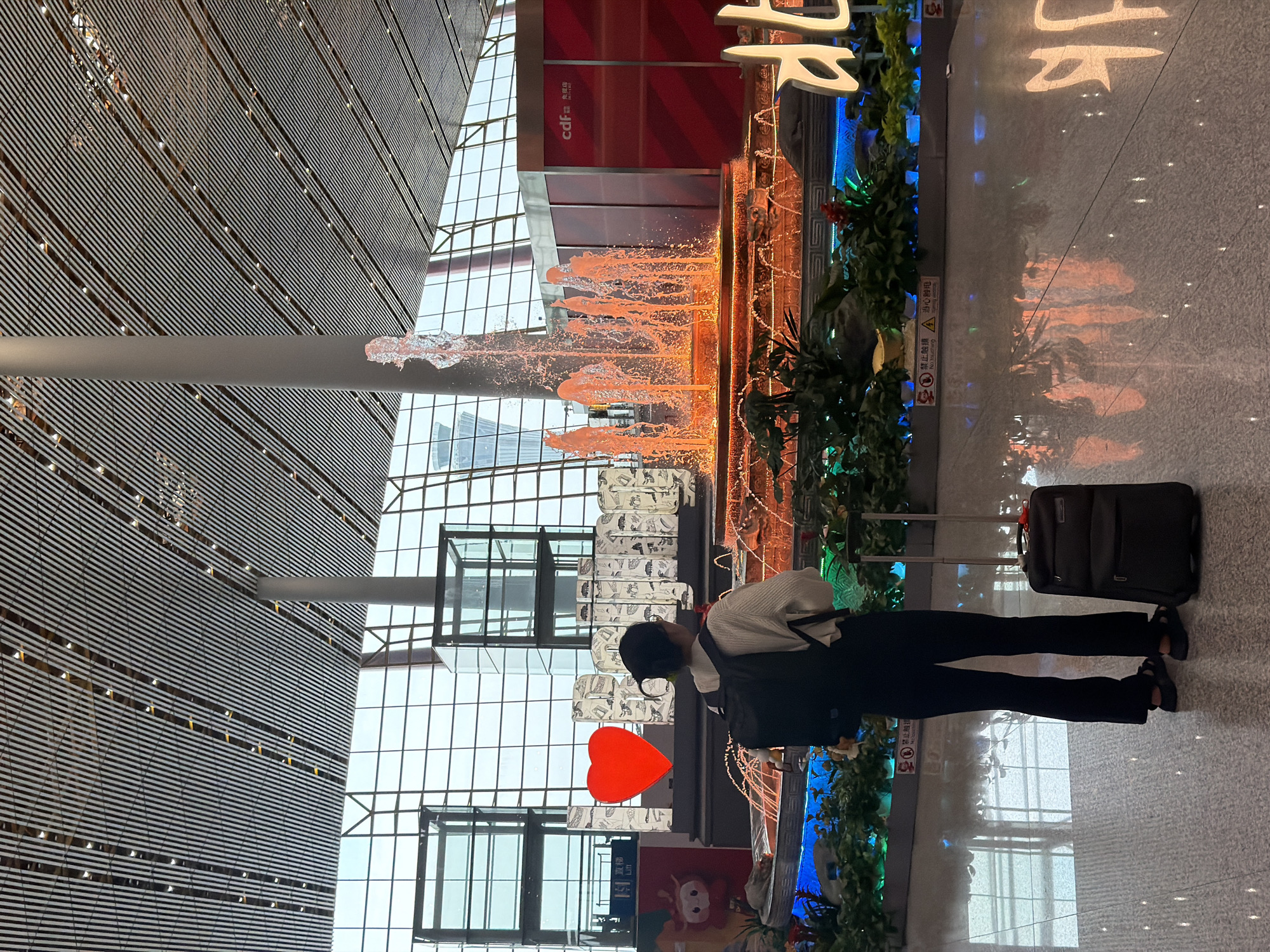 Inside Beijing airport's terminal, signs and fountains fill the space.