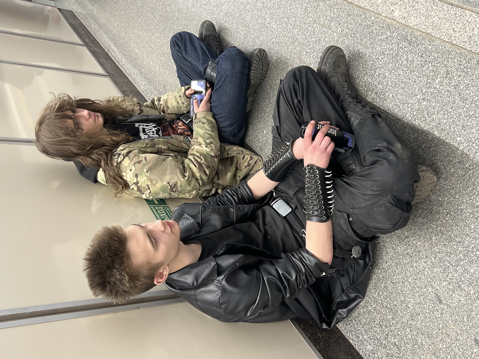 Two people sit on subway station floor in Saint Petersburg