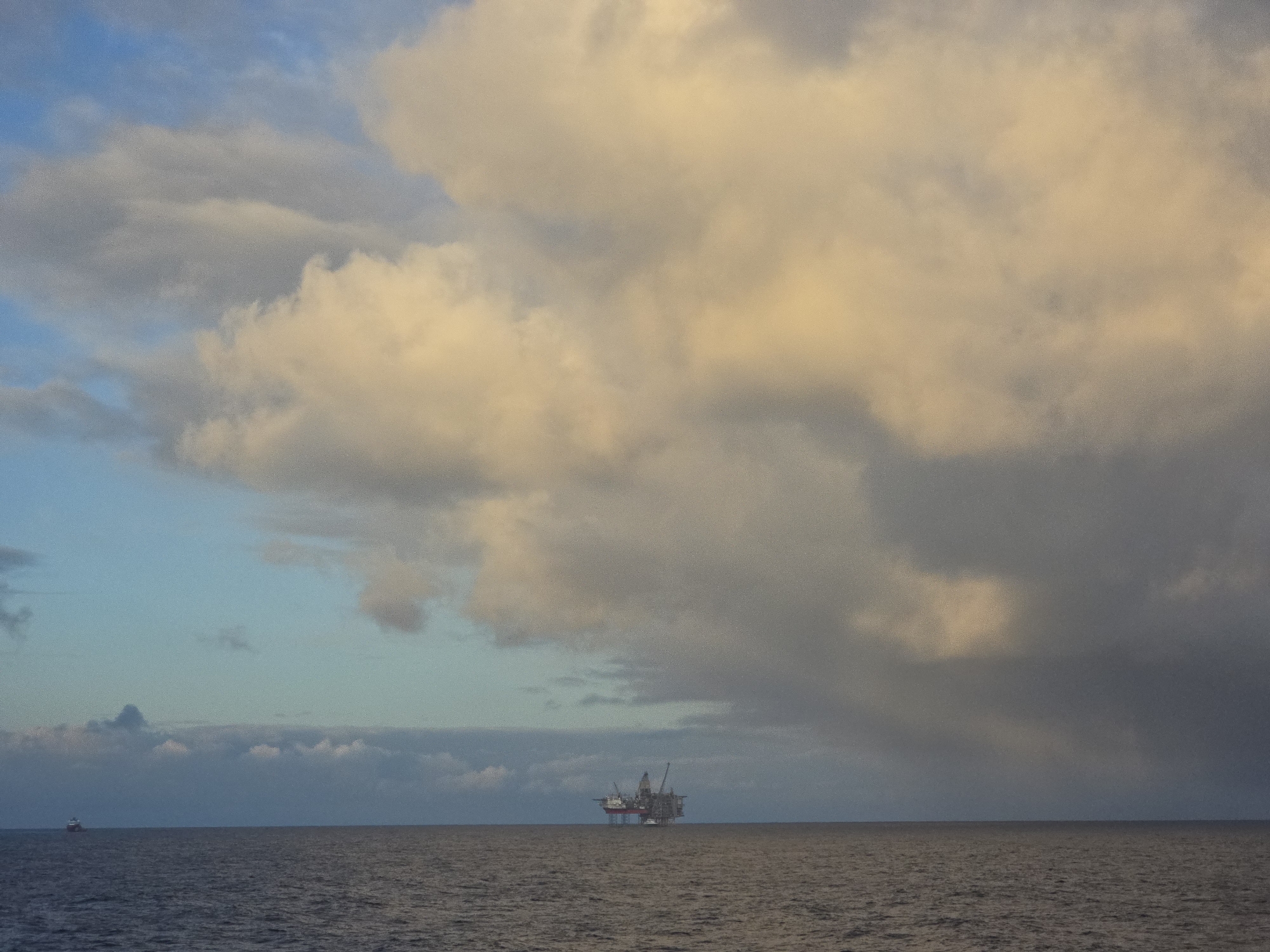Oil rig spotted in ocean under cloudy skies