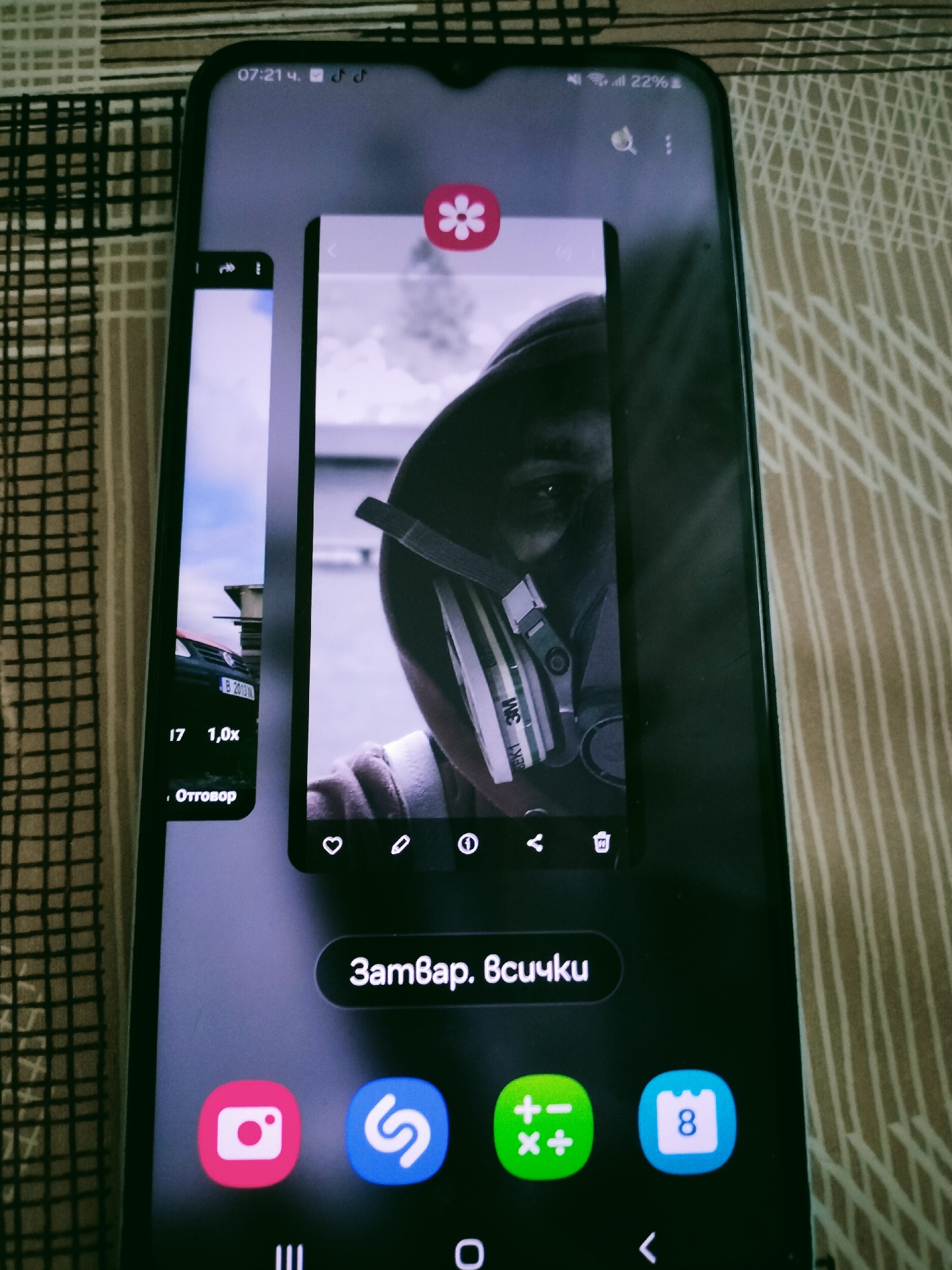 Smartphone displays windowed apps featuring black car photo