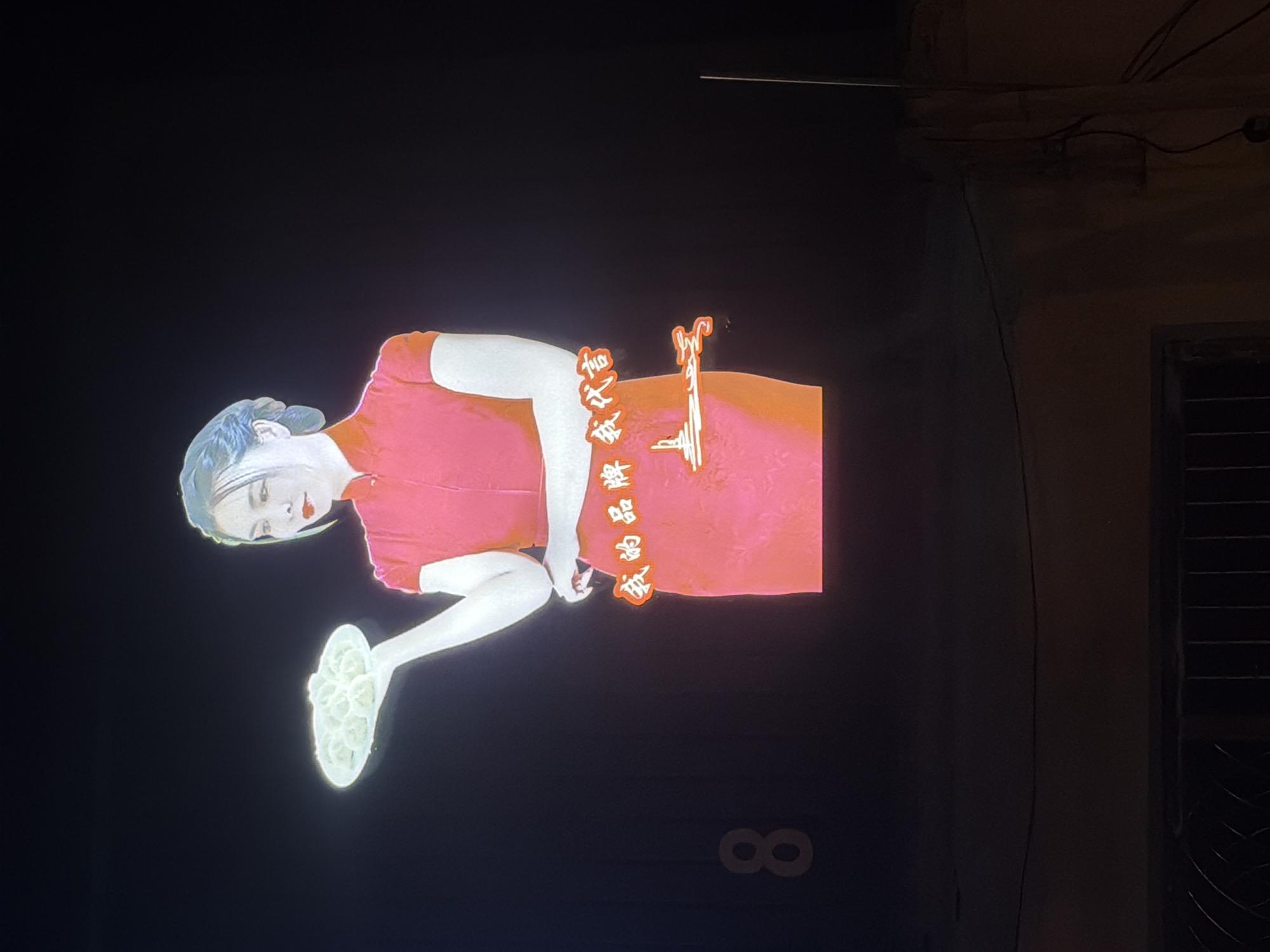 Dumpling advertisement projected on Zhongtun street amid parked vehicles