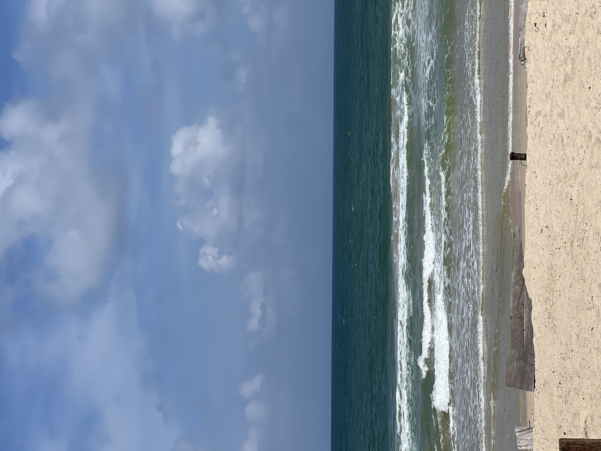Surfers and beachgoers on Choeng Thale's shores, cloudy summer morning