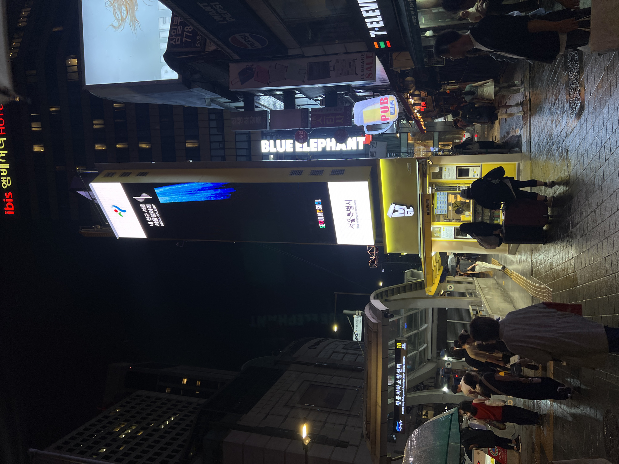 Rainy night on Seoul's busy Myeongdong street food strip