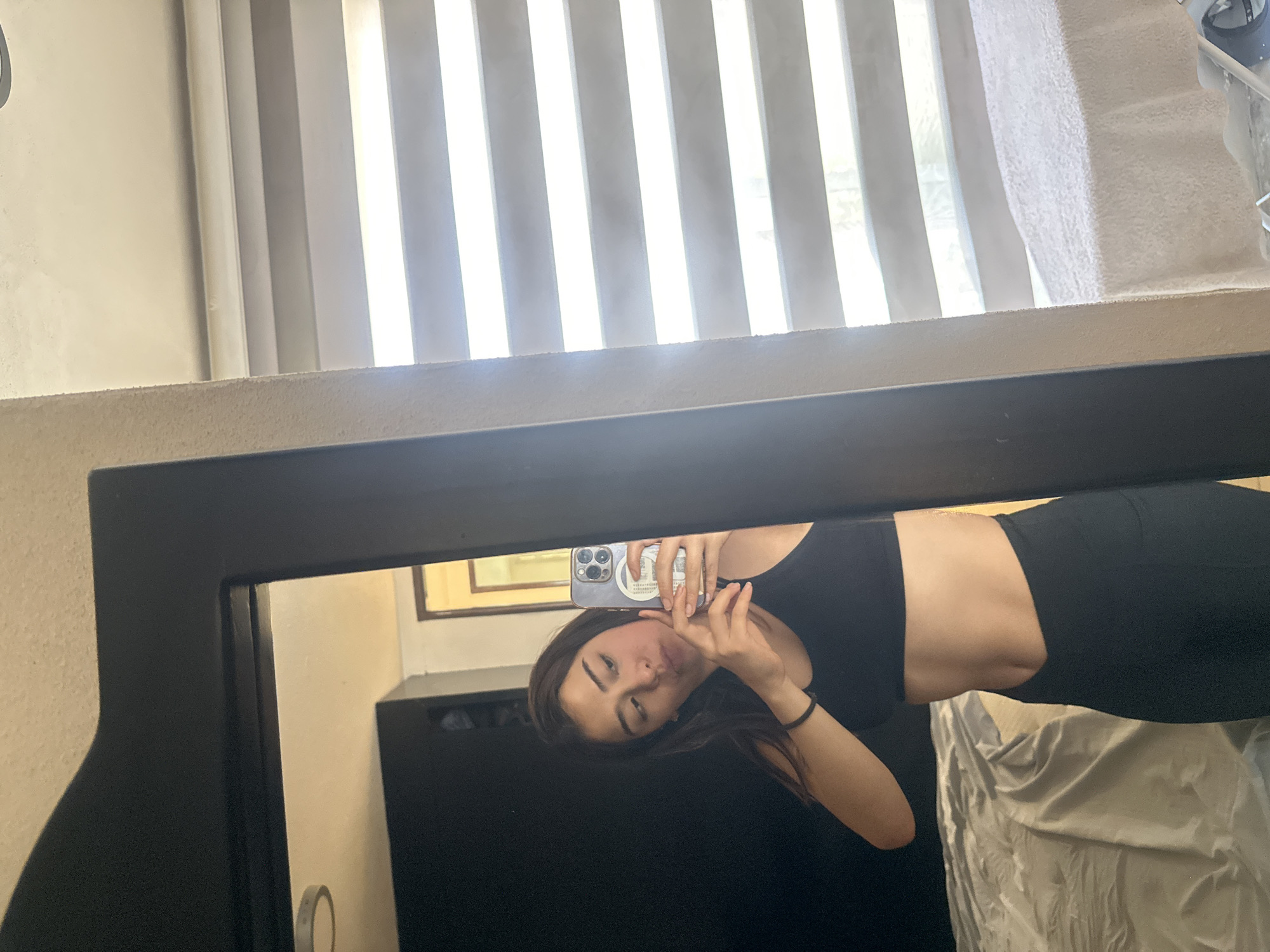 Young woman takes mirror selfie in Puebla room