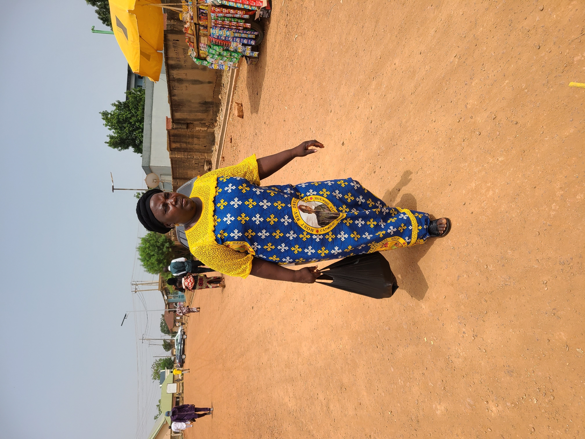 Two pedestrians spotted on dirt street in Jos, Nigeria