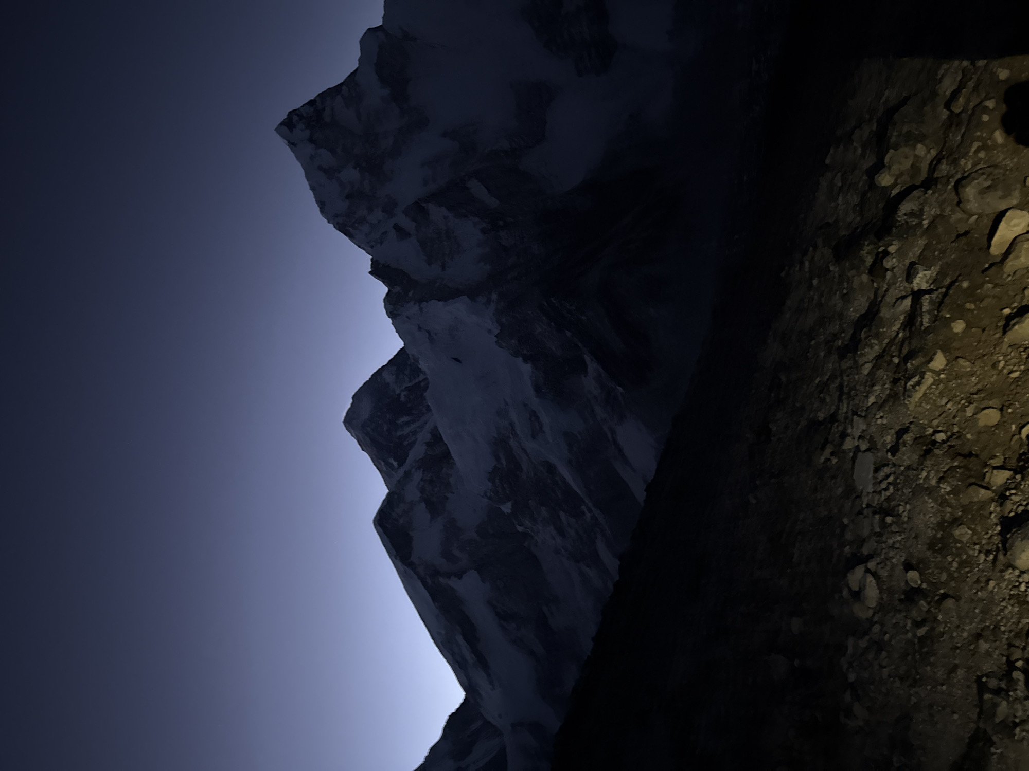 Trekkers climb rocky mountain path at twilight near Khumjung