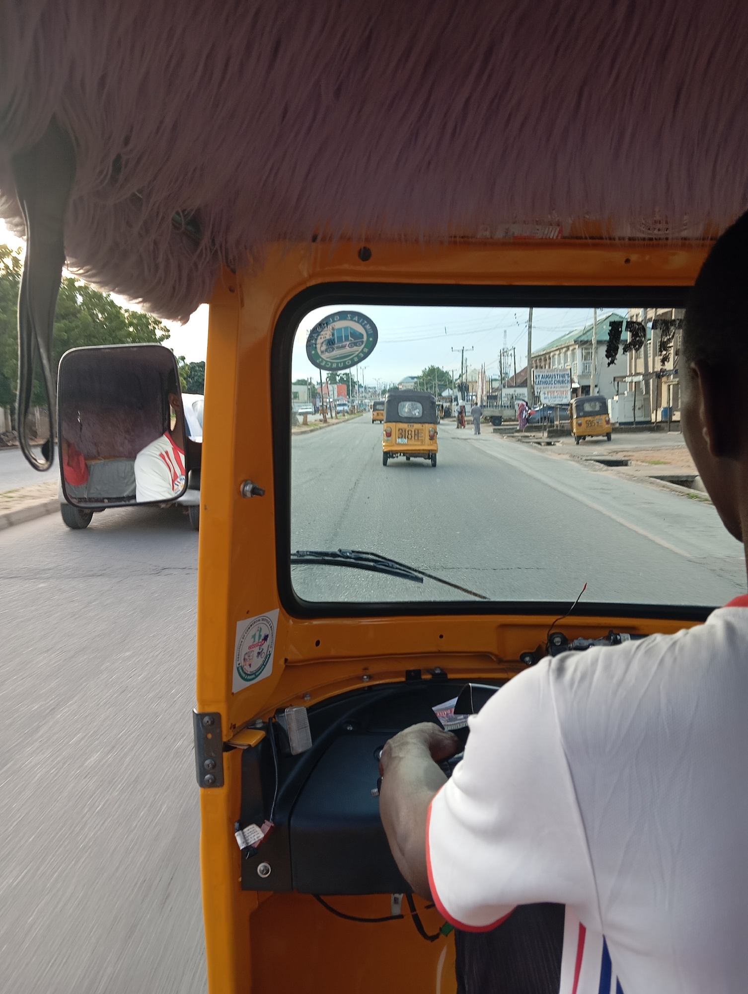 Street-level keke ride through Jalingo's busy commercial district