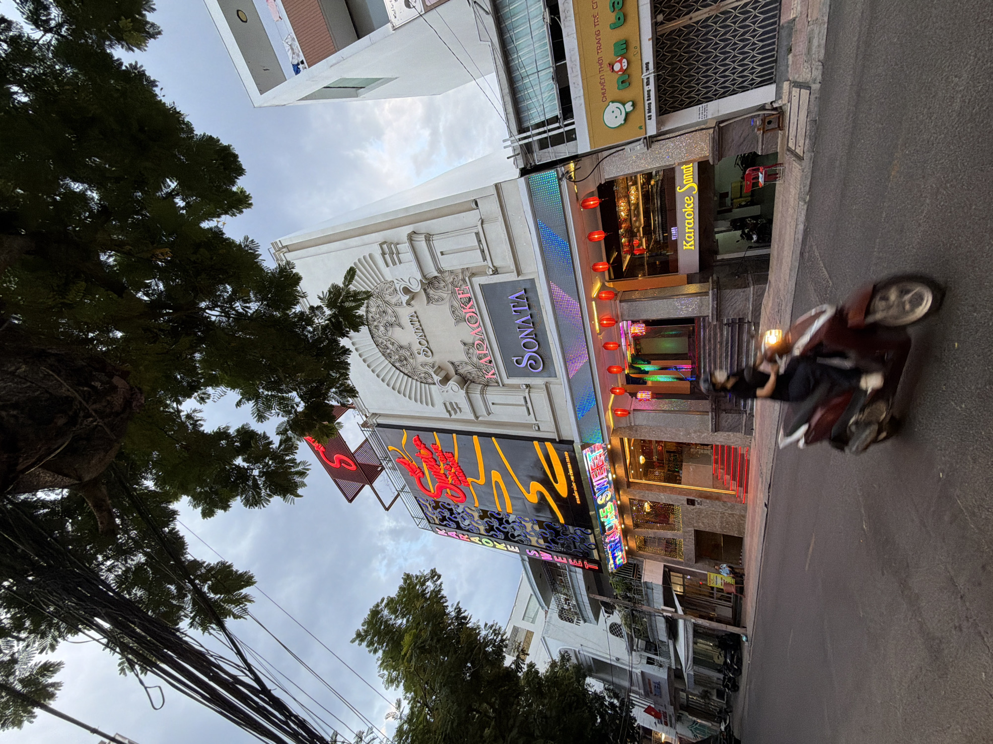 Nha Trang after dark: karaoke strips, misty alleys, and busy streets.