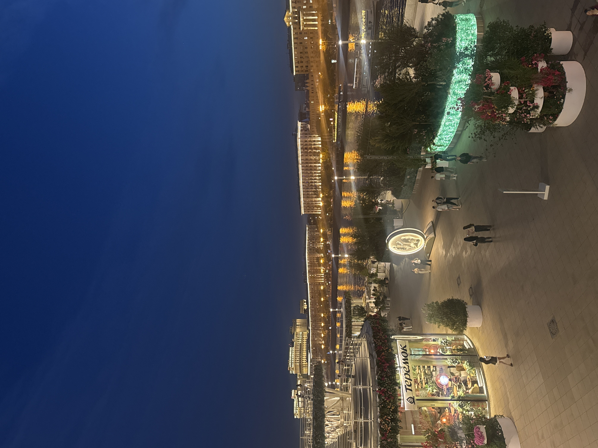Evening stroll captured along Moscow's illuminated Luzhkov Bridge waterfront