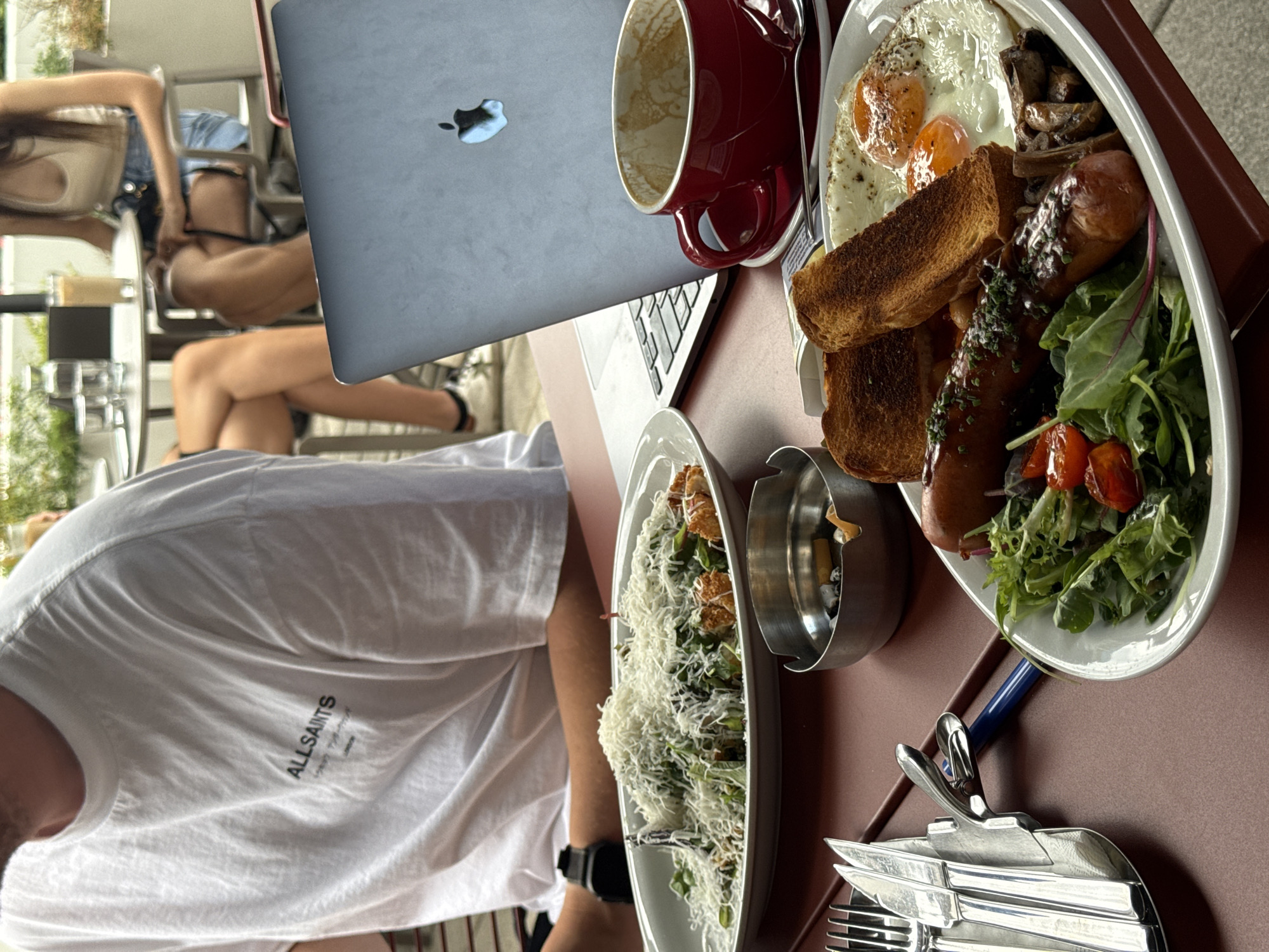 Lazy morning at a Belgrade outdoor café, food and laptops out
