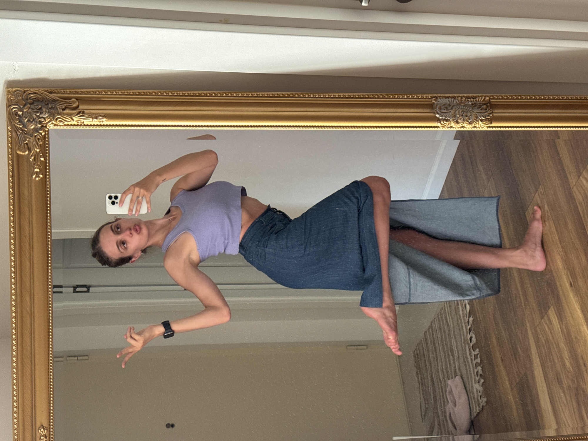 Woman takes mirror selfies indoors, urban hillside views captured