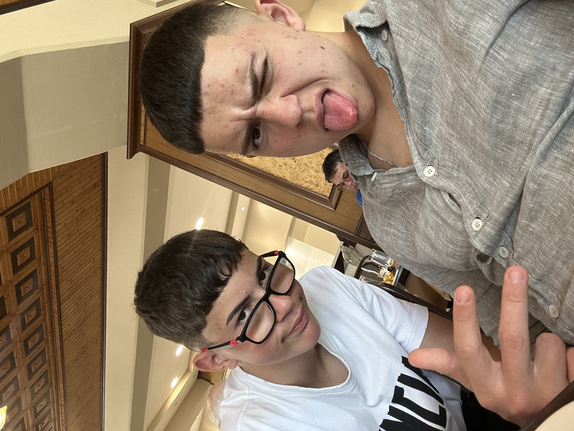 Teenagers take playful selfies at Kalabaka restaurant during tourist lunch