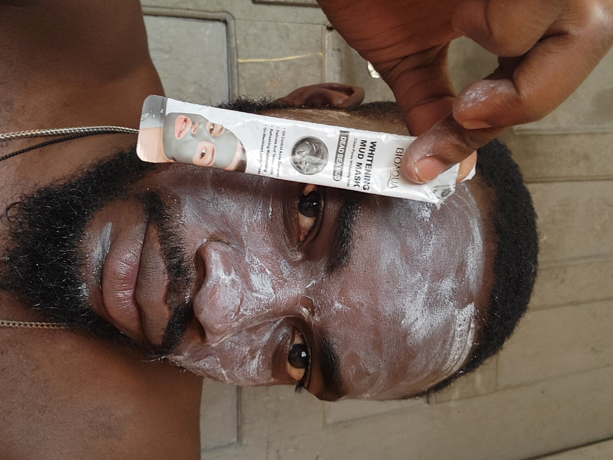 Man applies facial masks during skincare routine in Jos